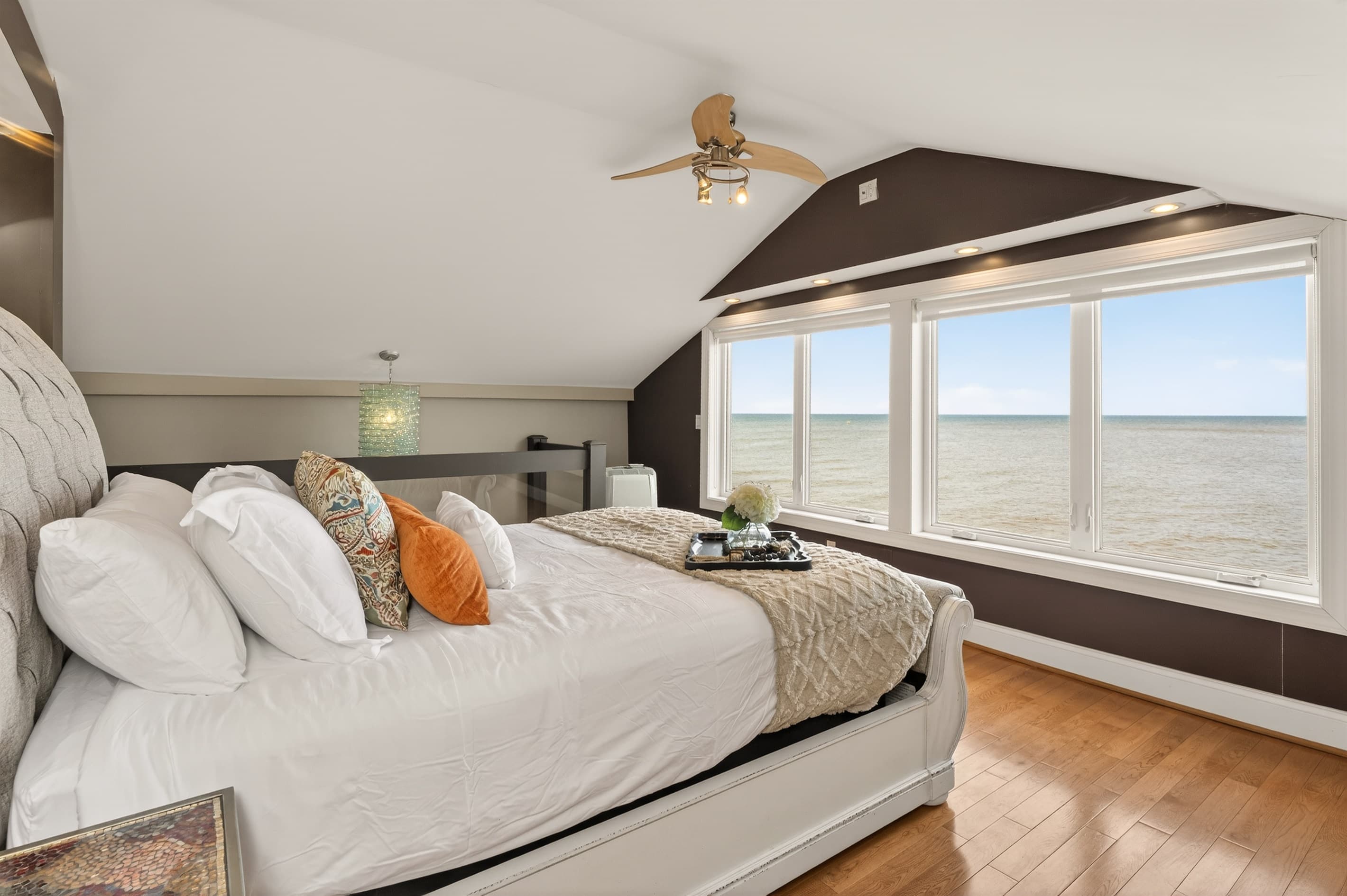 Bed positioned beneath wide windows