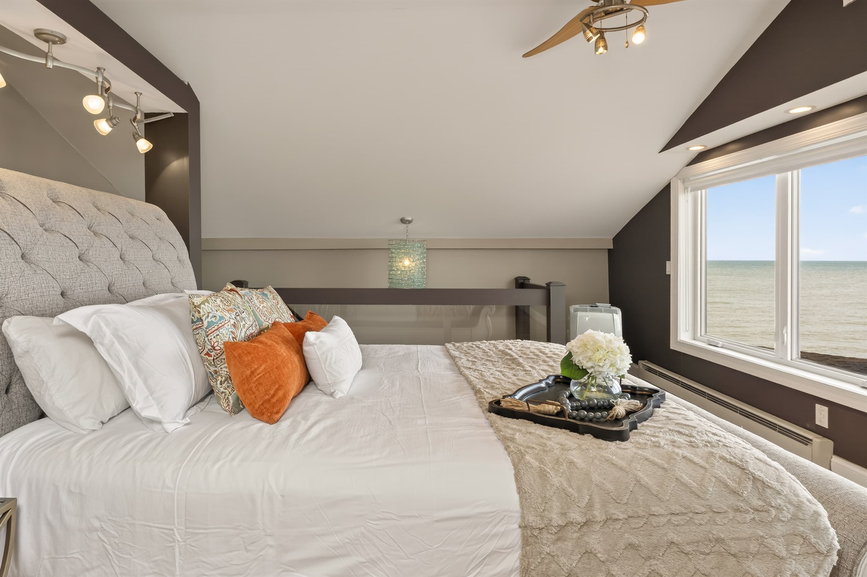 Upholstered bed with orange accent pillow