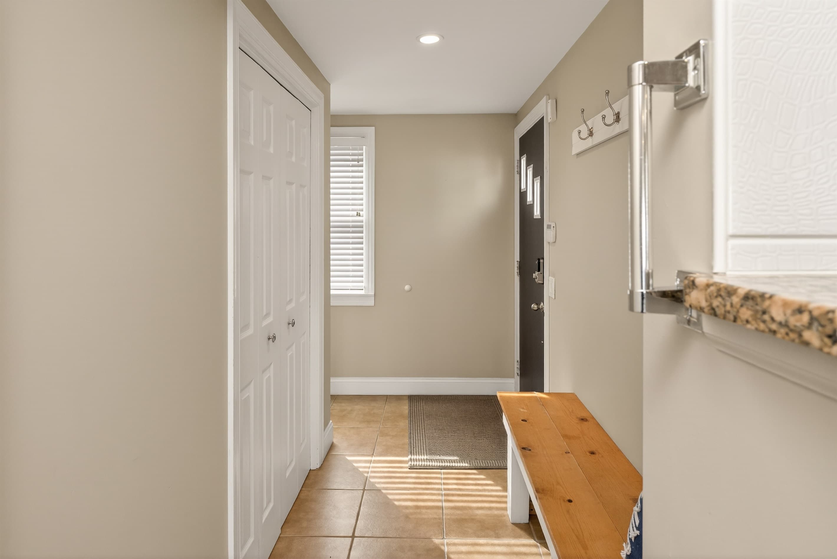 Hallway with wooden bench and tiled floor