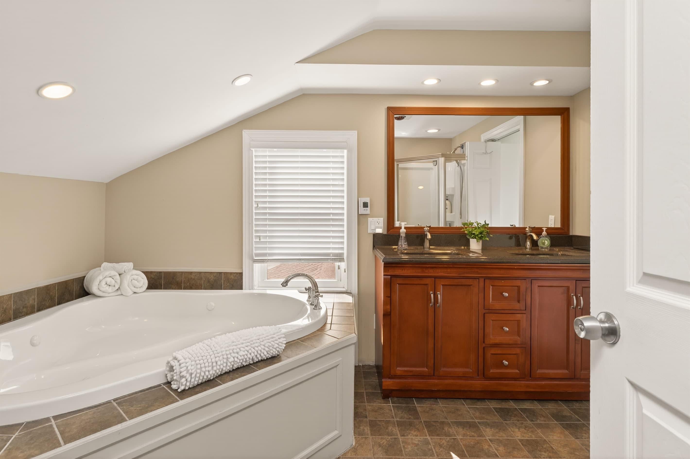 Bathroom with bathtub and wooden vanity