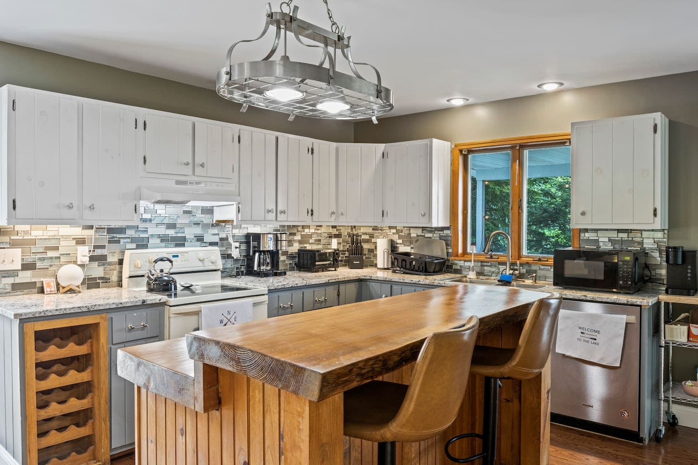 Kitchen with white cabinetry and wood island