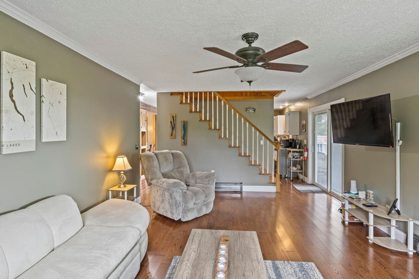 Living room with staircase and ceiling fan