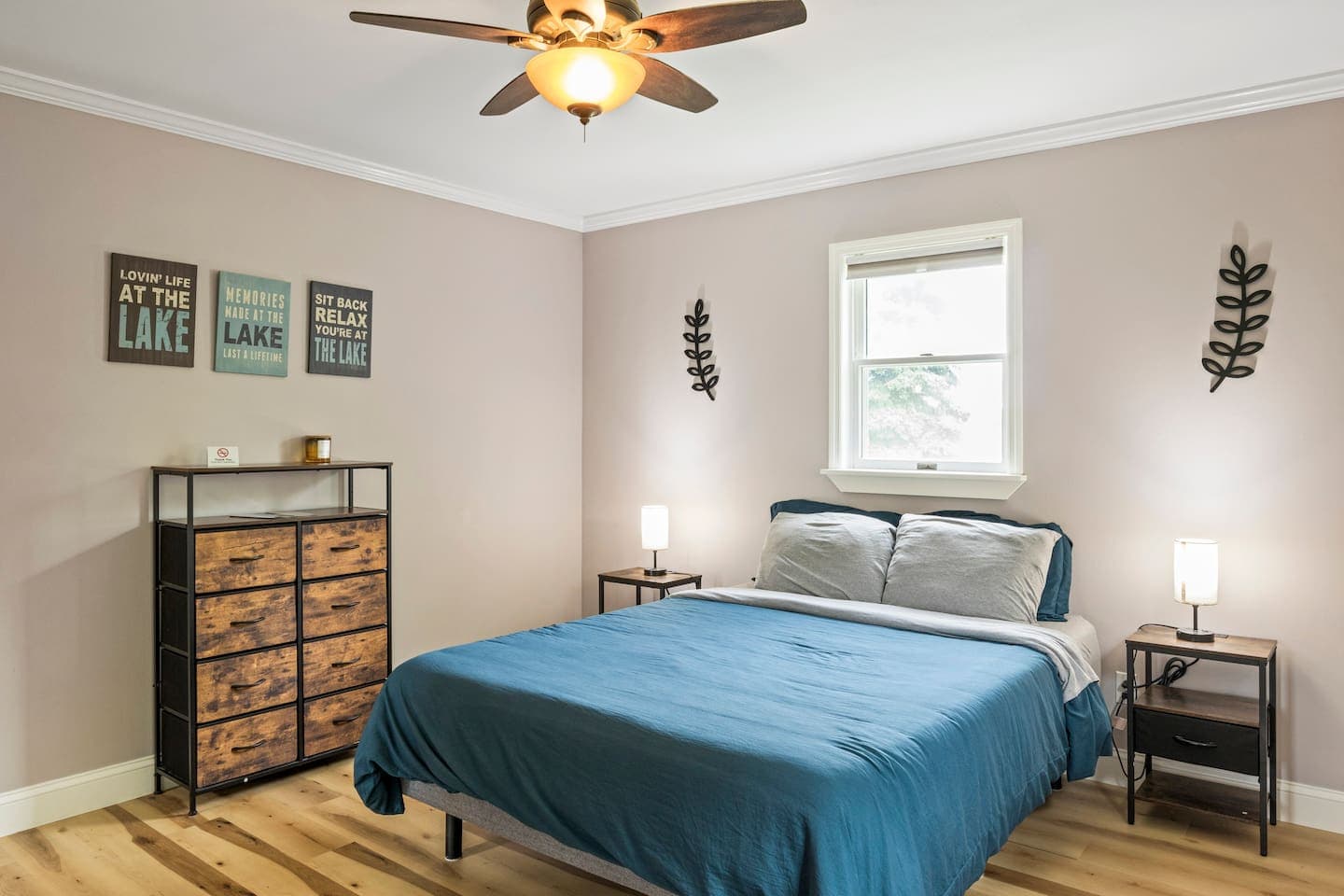 Bedroom with blue bedding and wood dresser