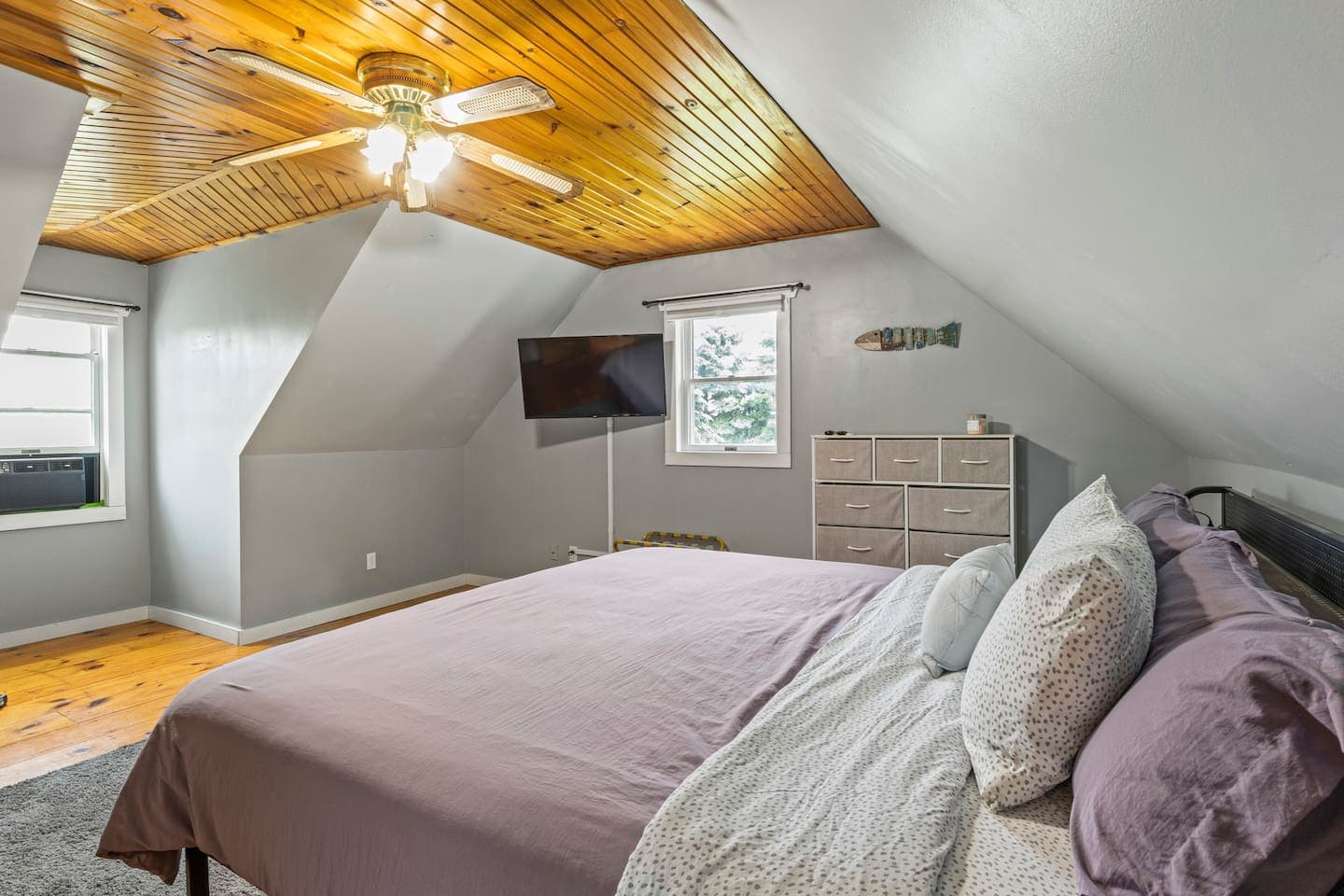 Bedroom beneath a sloped wood ceiling