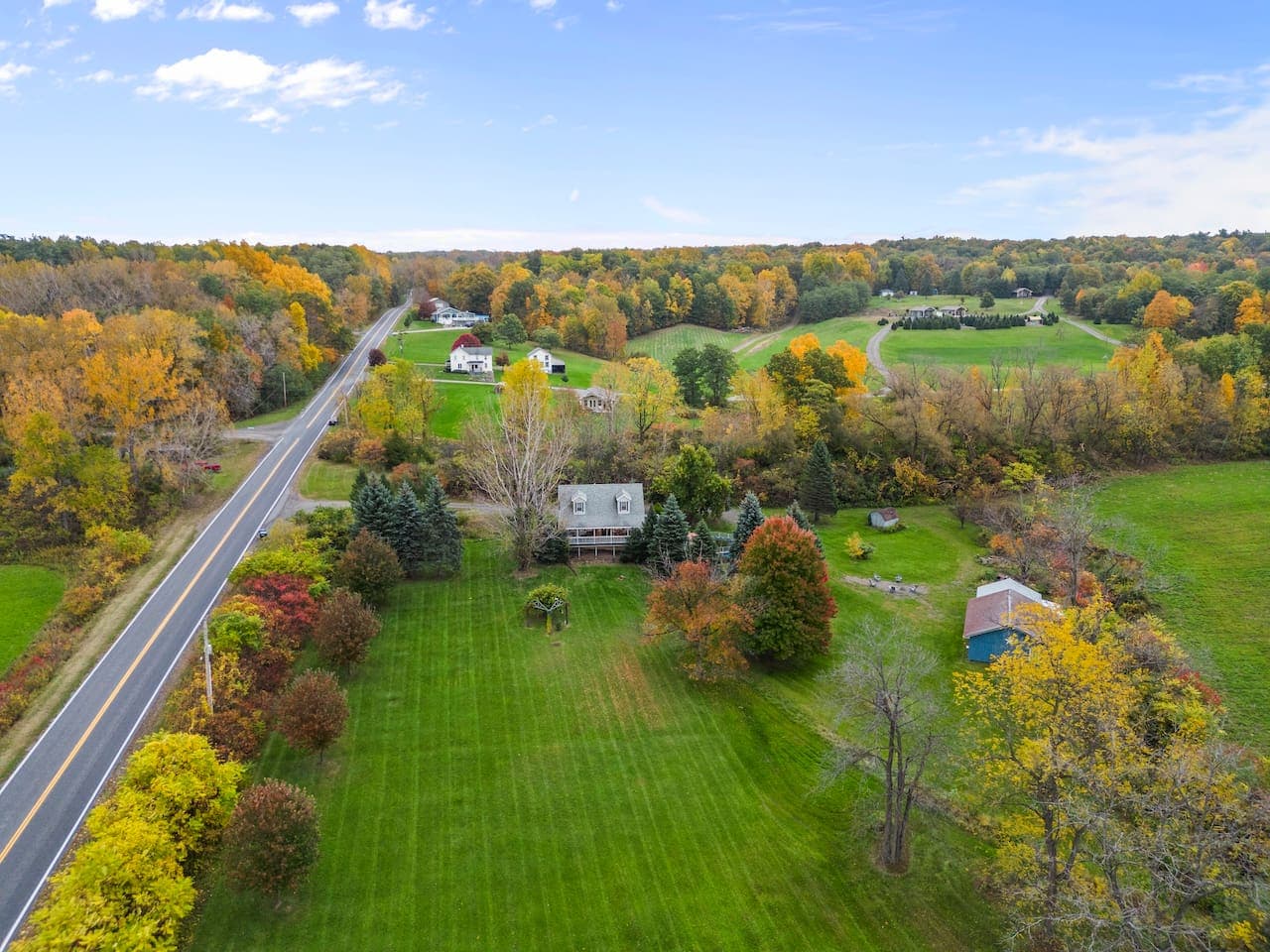 Property surrounded by fields and autumn trees