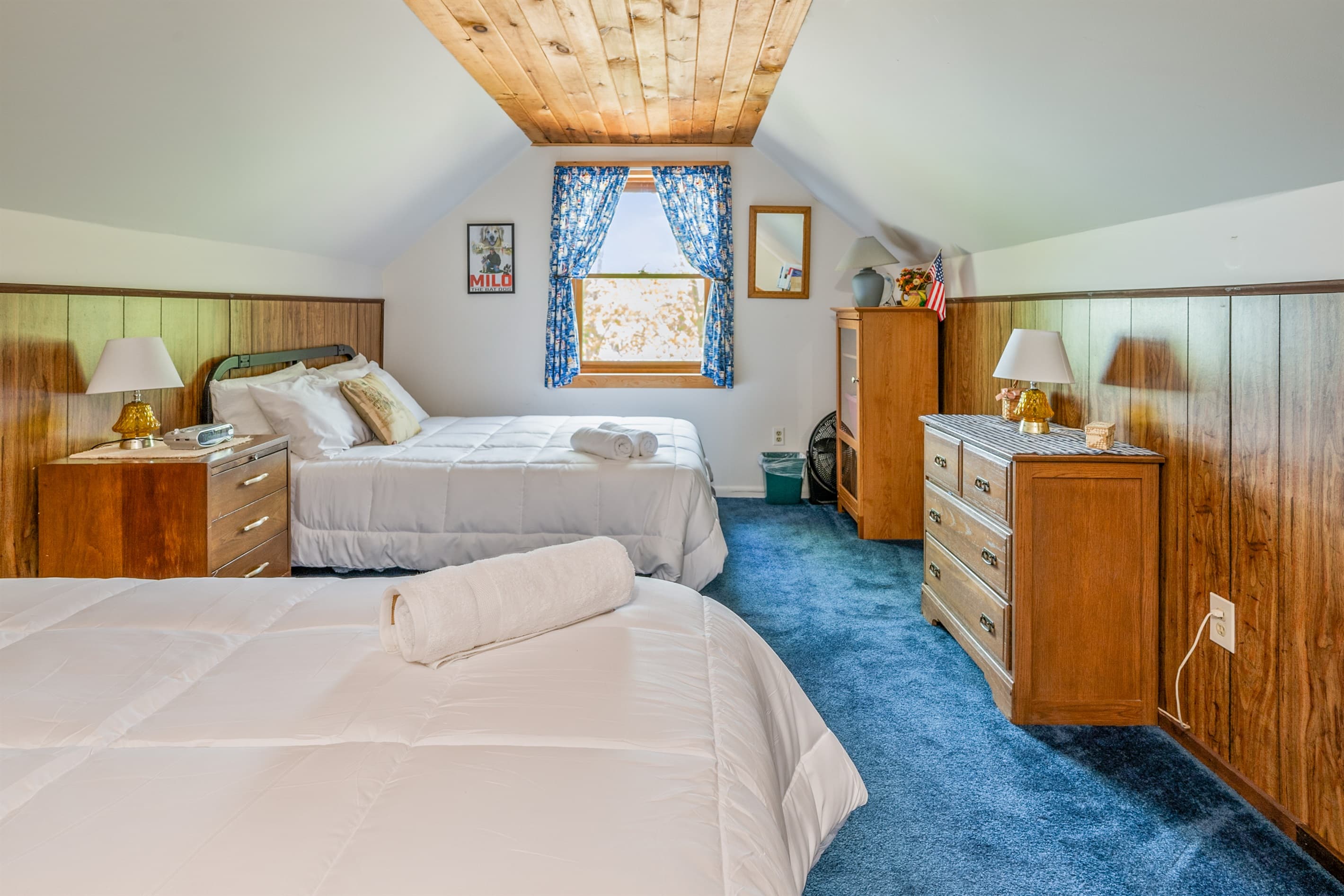 Beds separated by wooden dresser