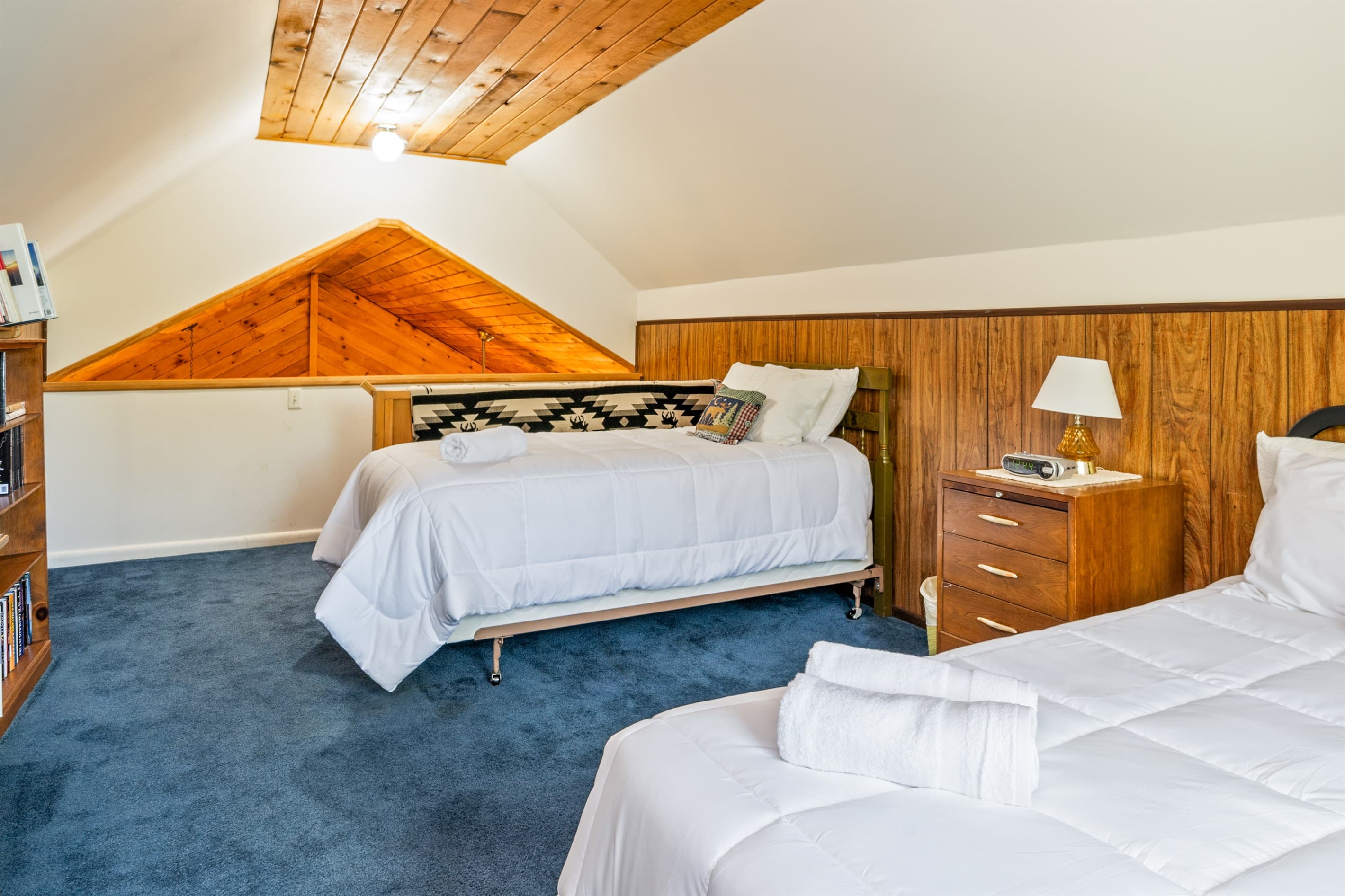 Bed beside dresser and bookshelf