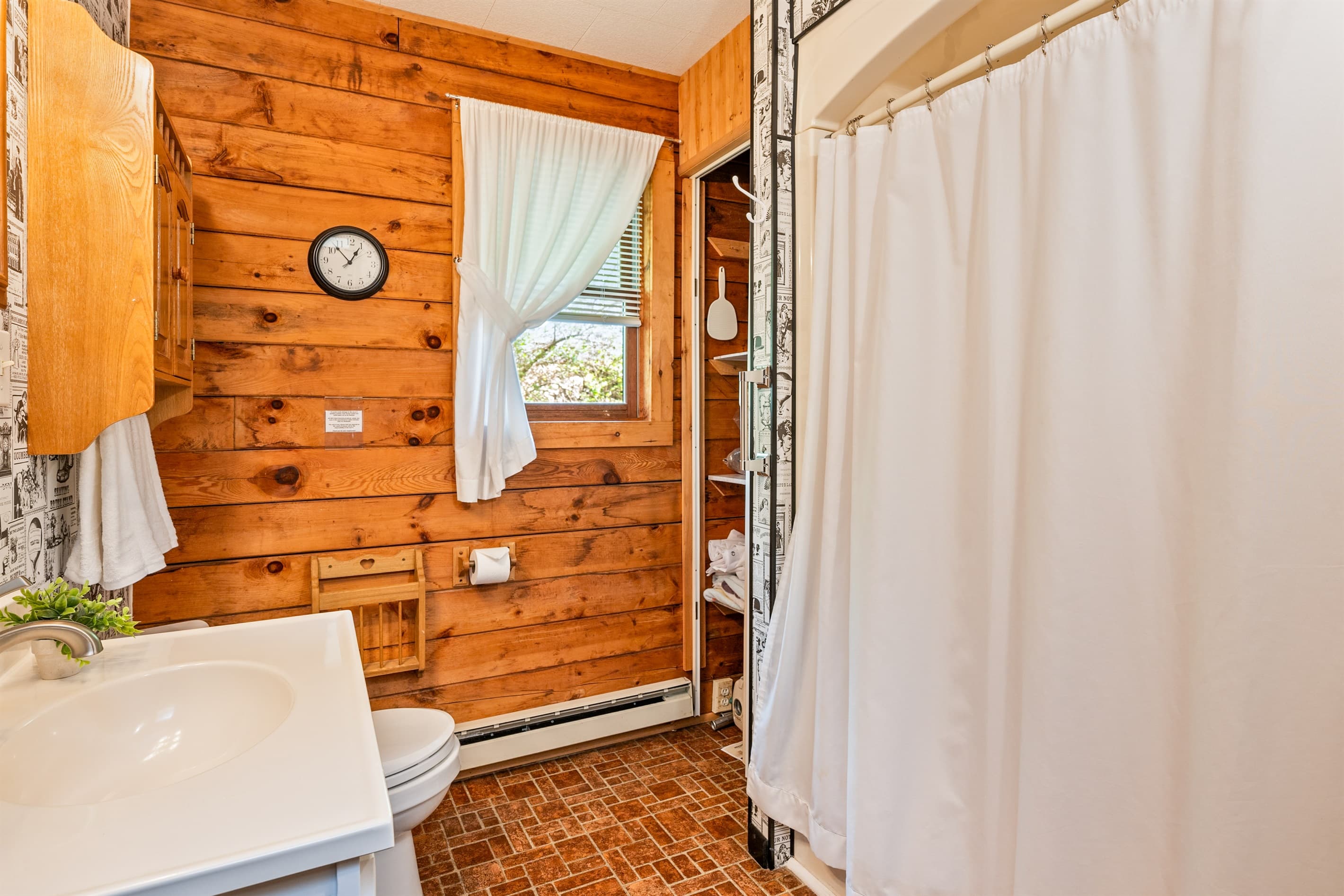 Bathroom with curtained shower and wooden walls
