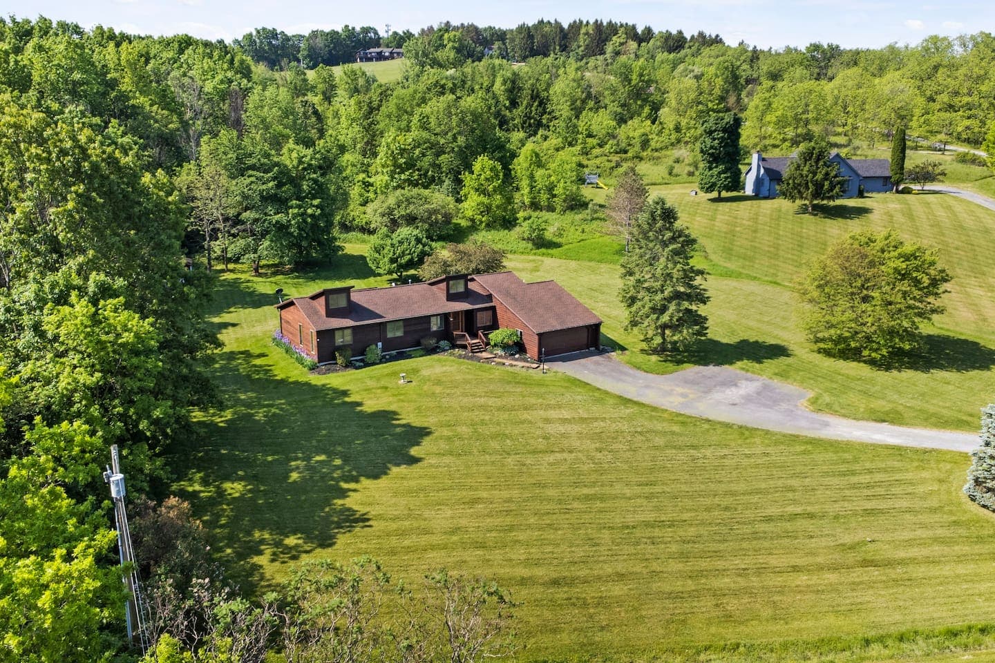 Aerial view of home, driveway, and surrounding lawn