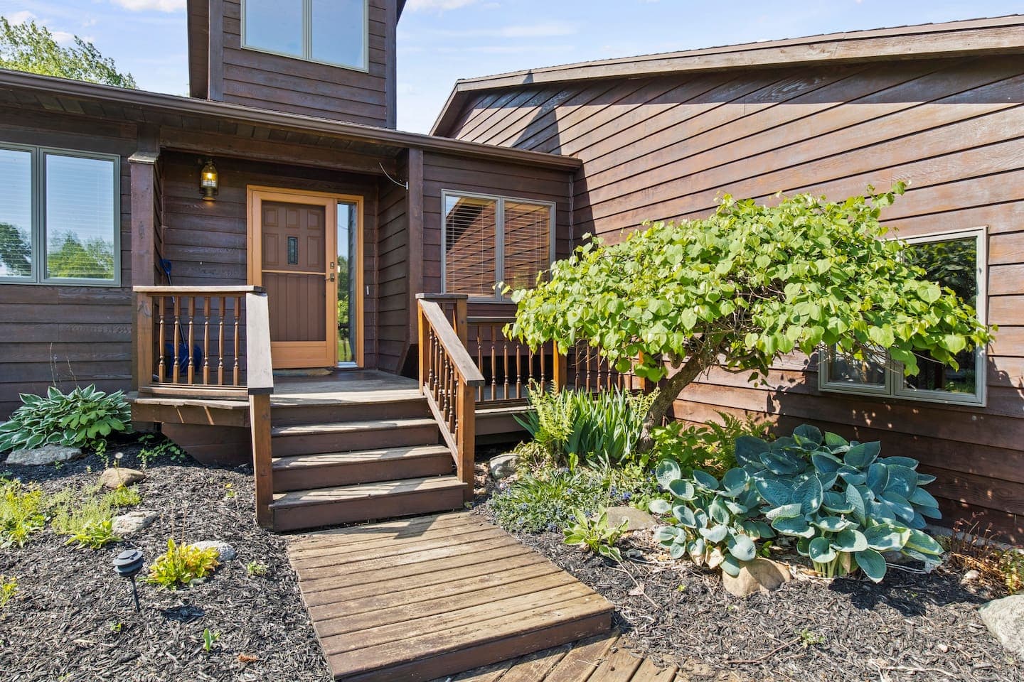 Front steps bordered by dense landscaping