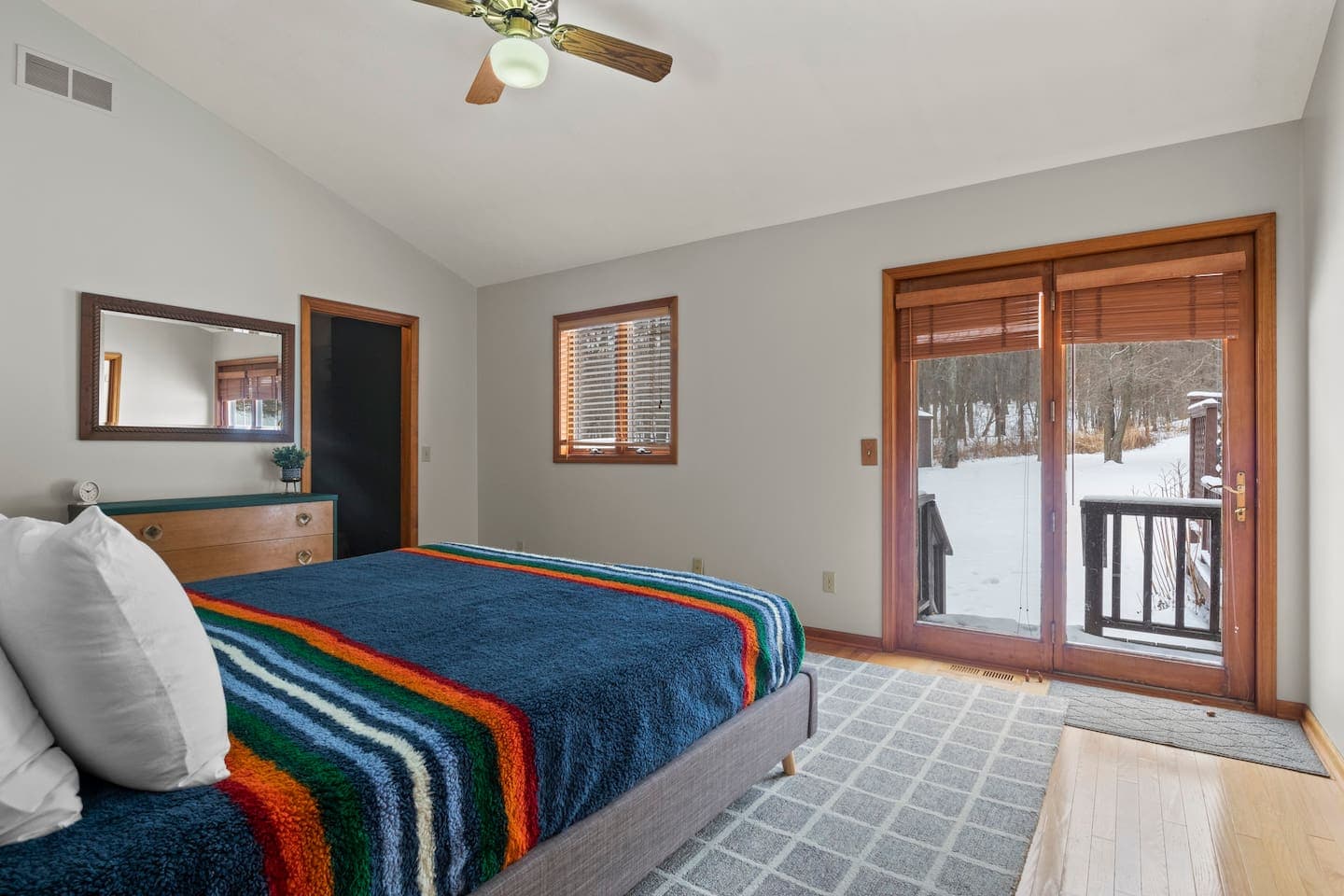 Bedroom with striped bedding and deck access