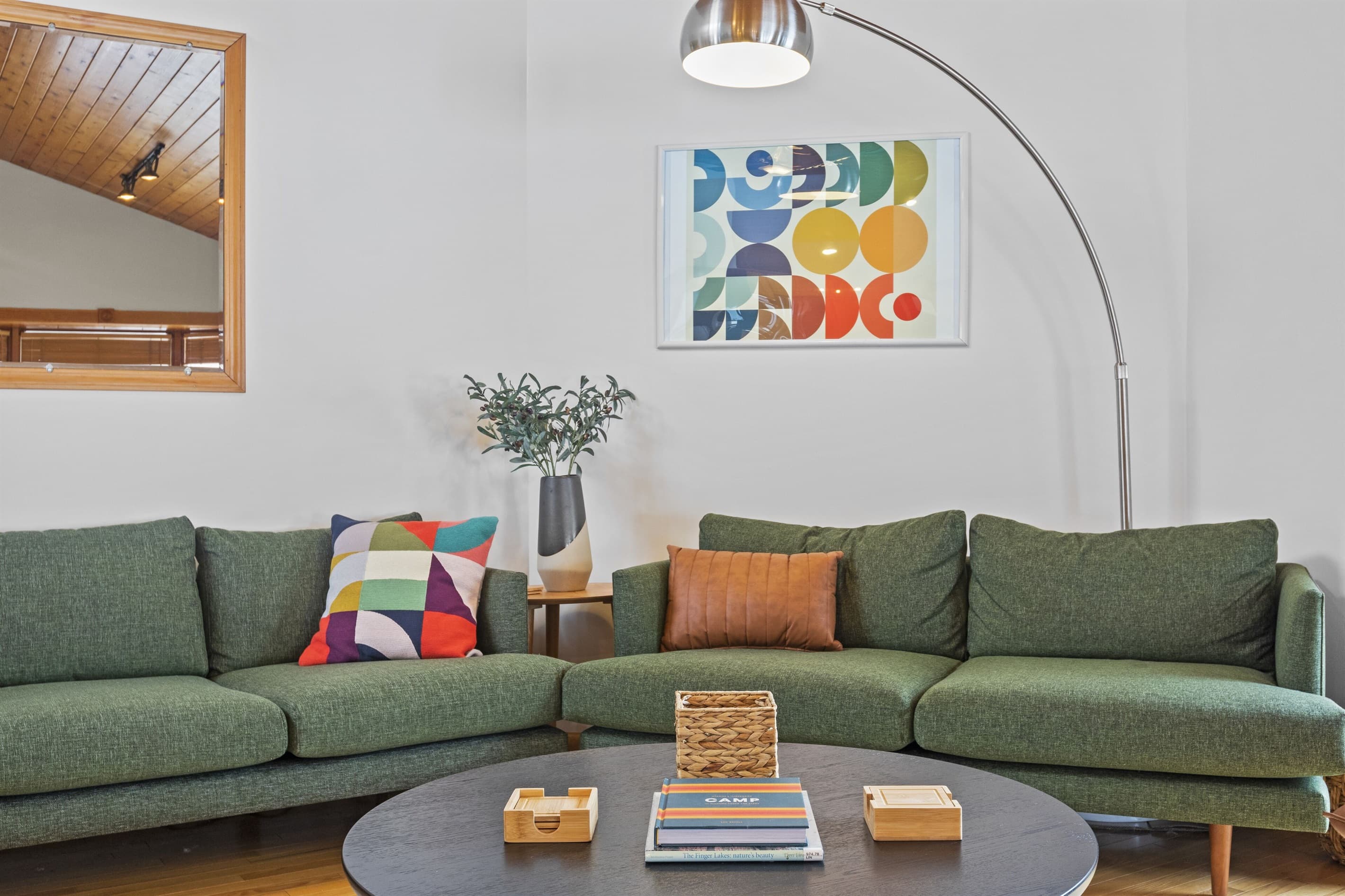 Living room with green sectional and colorful artwork