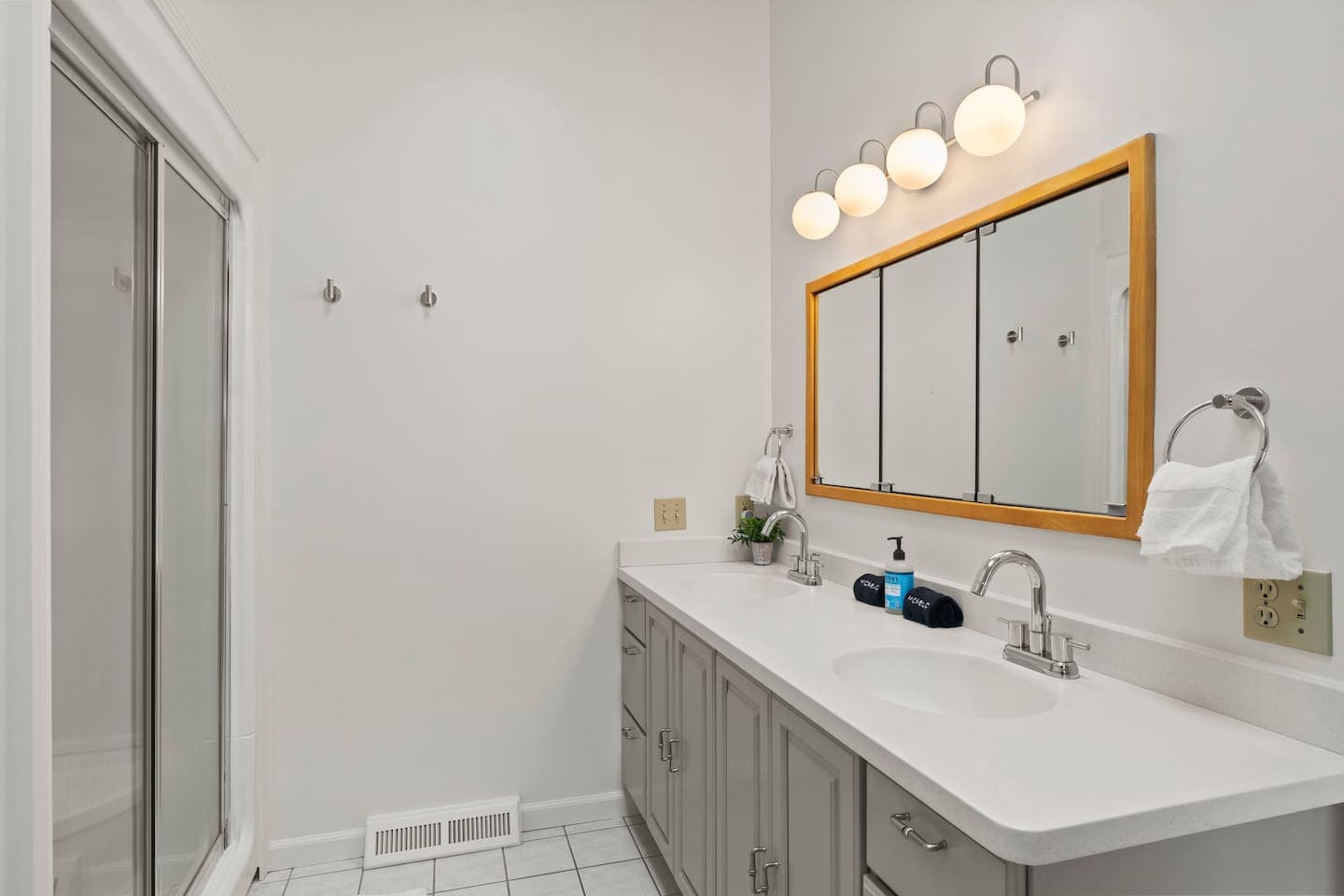 Double vanity beneath wooden-framed mirrors