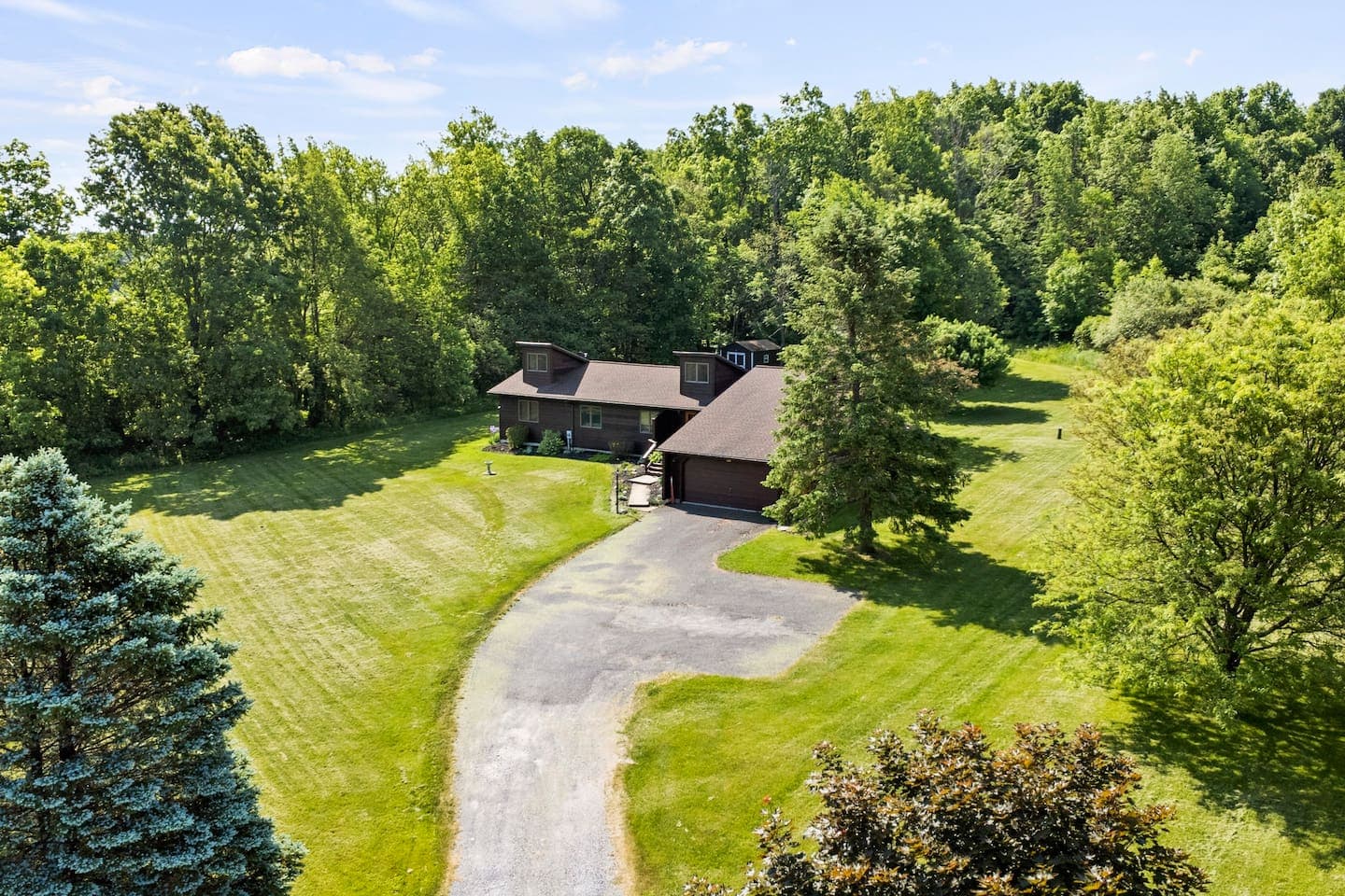 Home surrounded by open lawn and trees