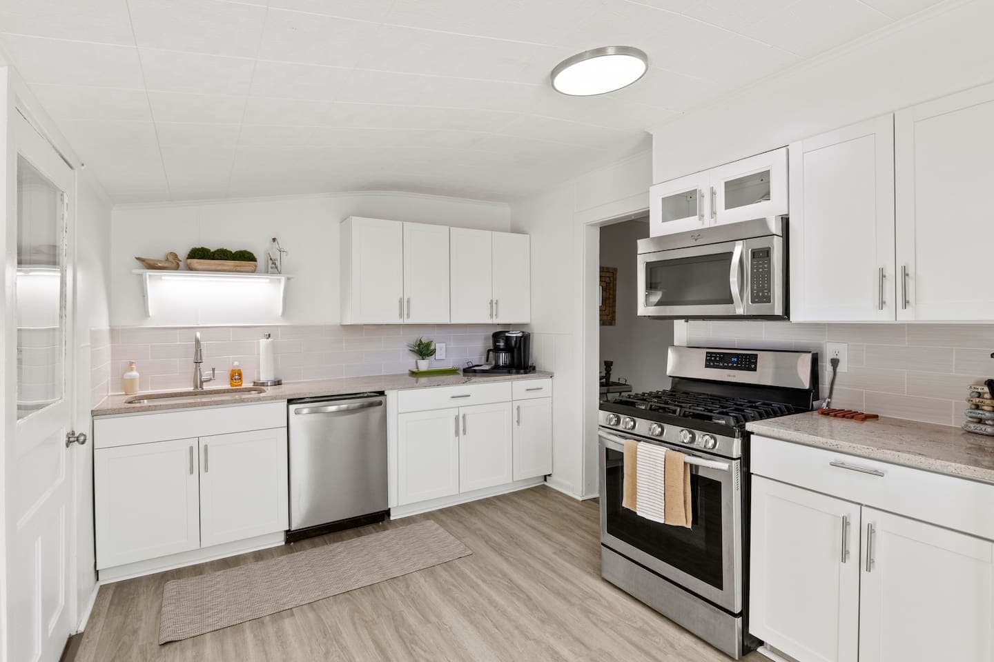 Kitchen with white cabinetry and black appliances