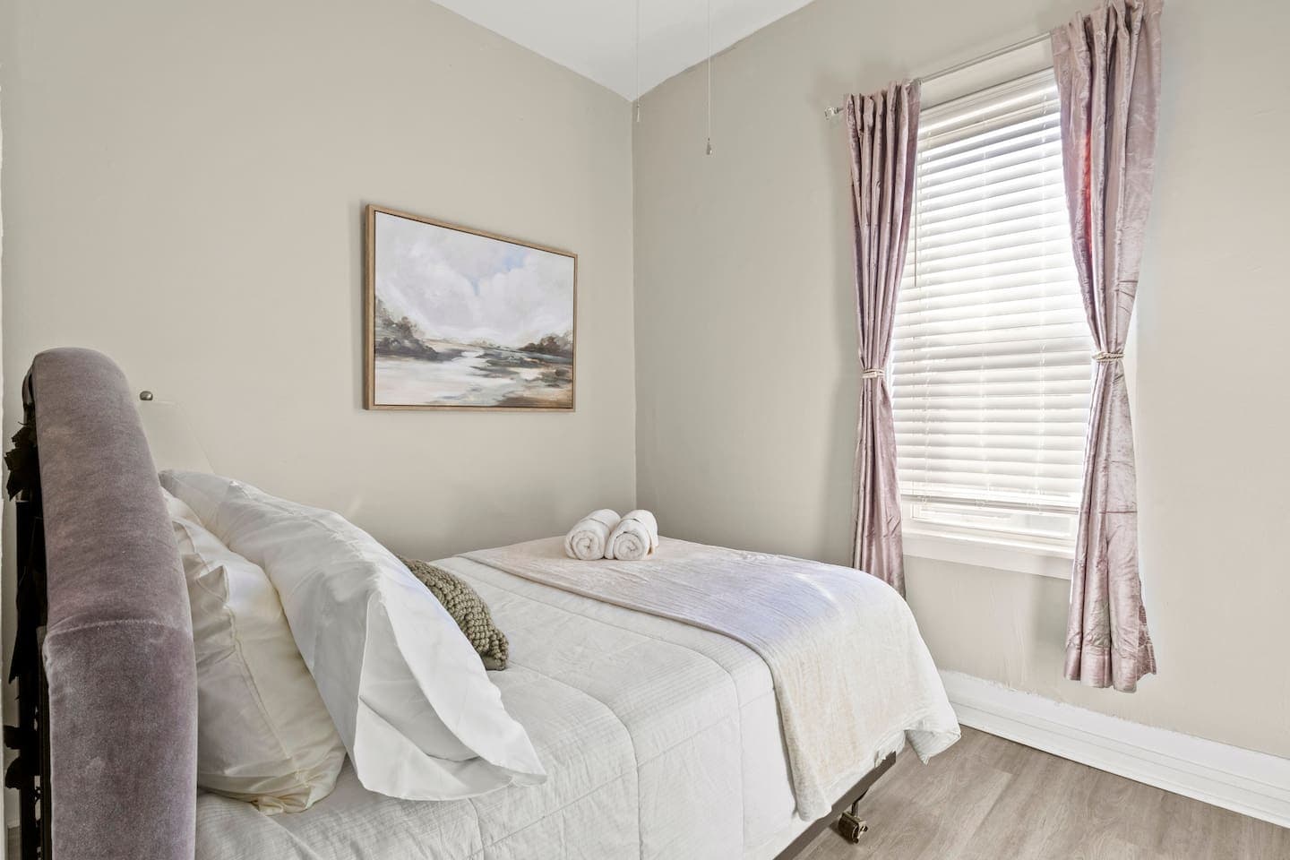 Bedroom with soft bedding and framed artwork