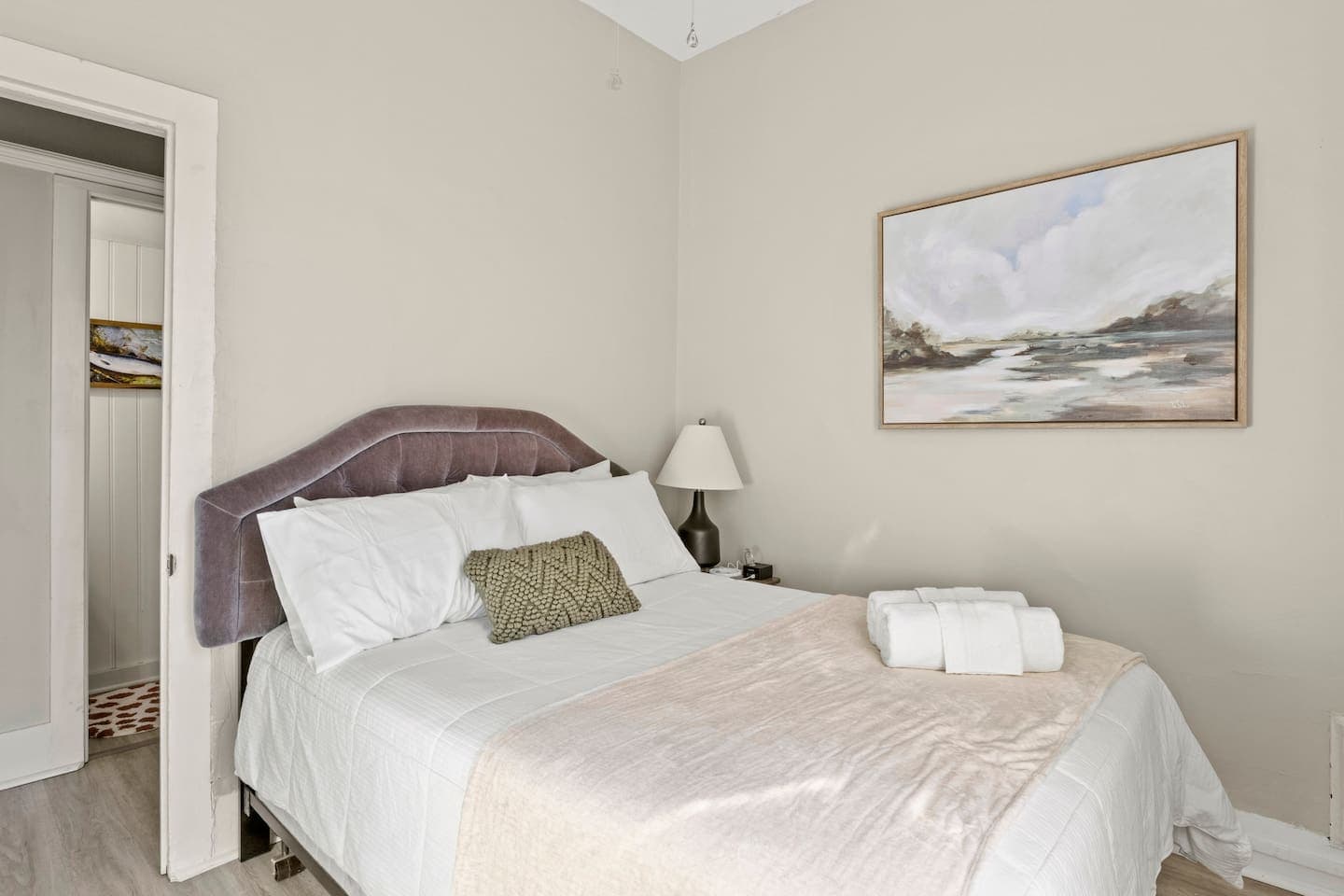 Bedroom with upholstered bed and wall art