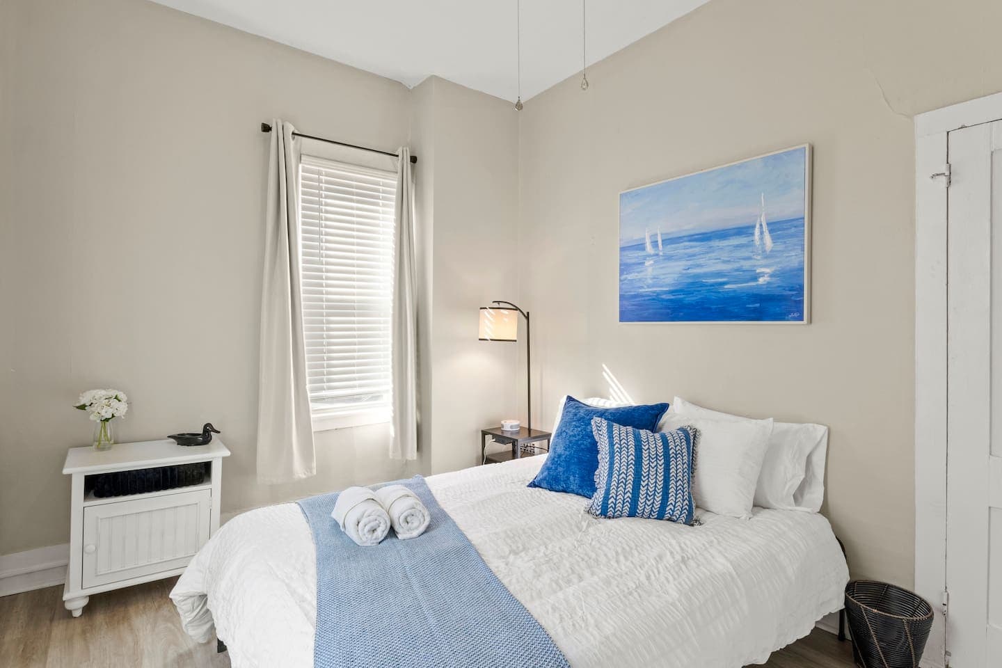 Bedroom with blue accents and coastal artwork