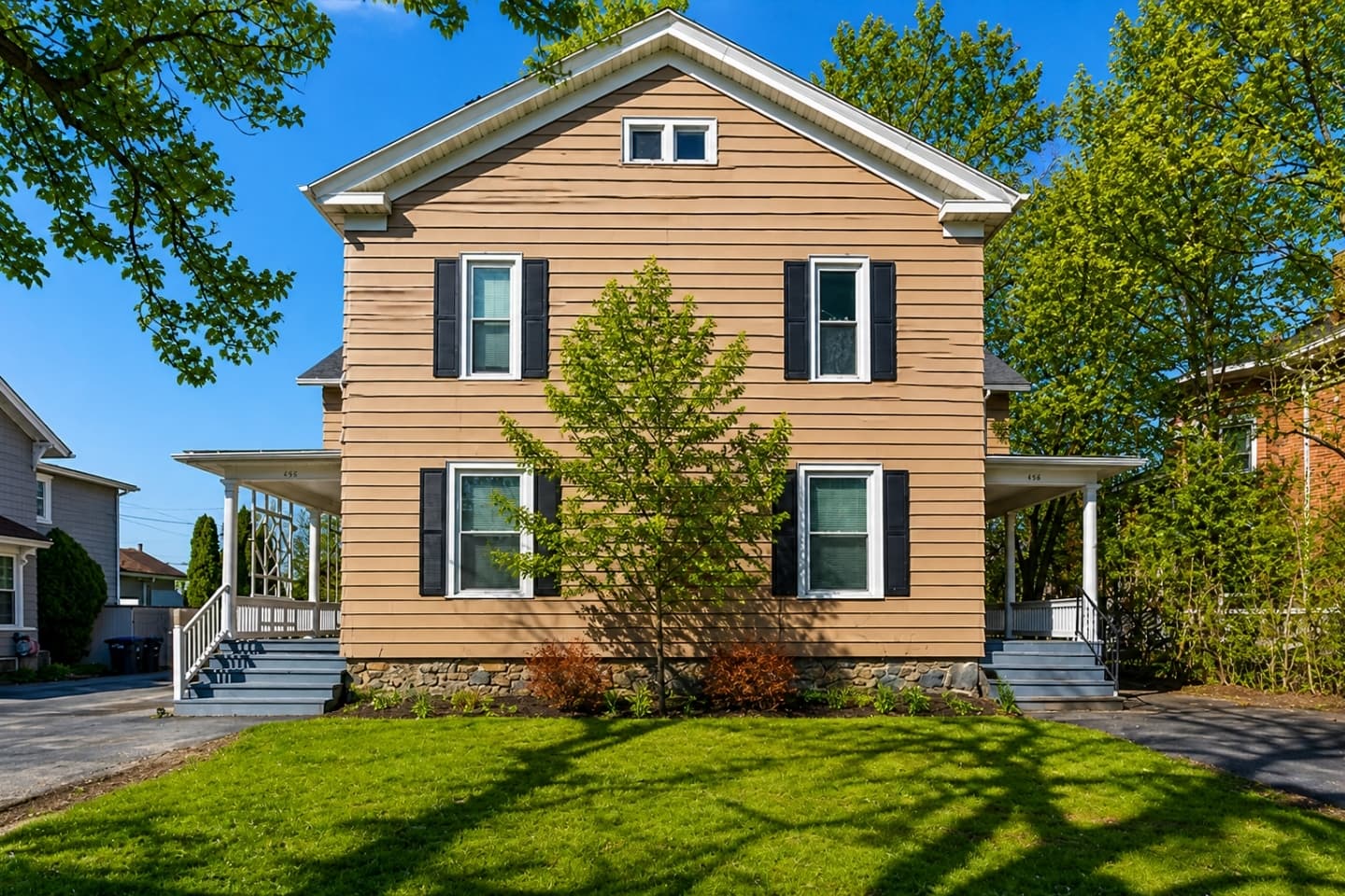 Brick home framed by mature trees