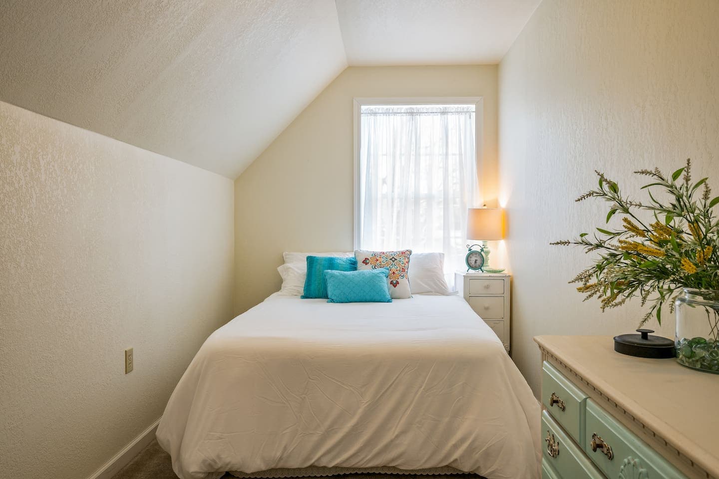 Bedroom with sloped ceiling and natural light