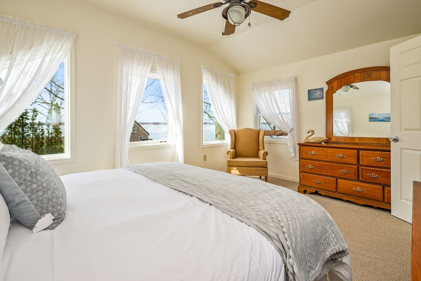 King bedroom with dresser and large windows