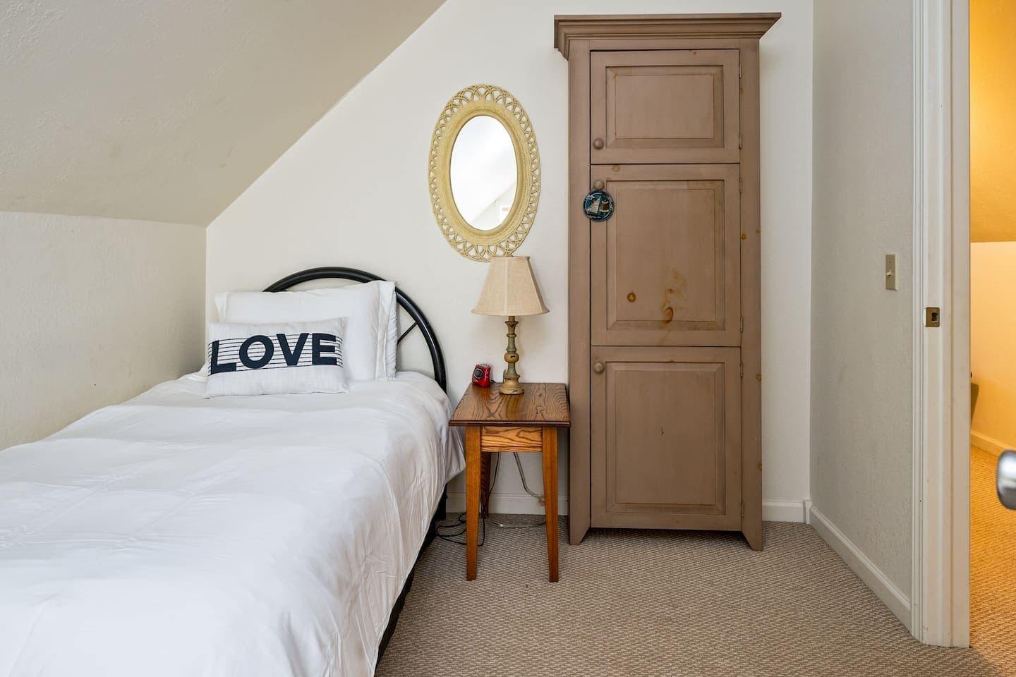 Bedroom with wood armoire and round mirror