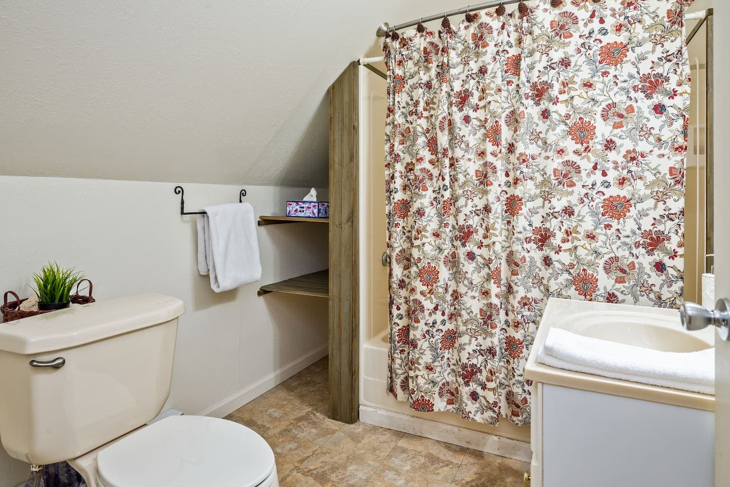 Bathroom with tub and floral shower curtain