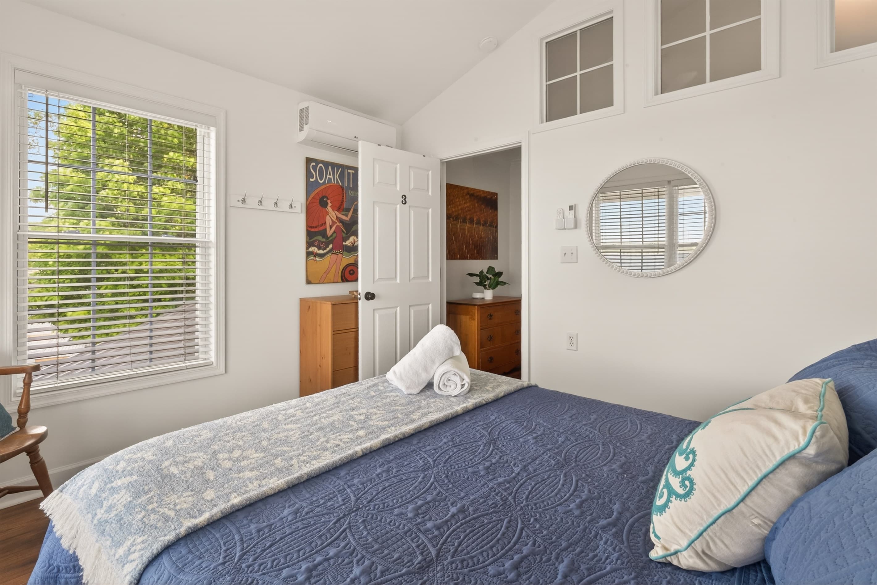 Bedroom with dresser and round mirror