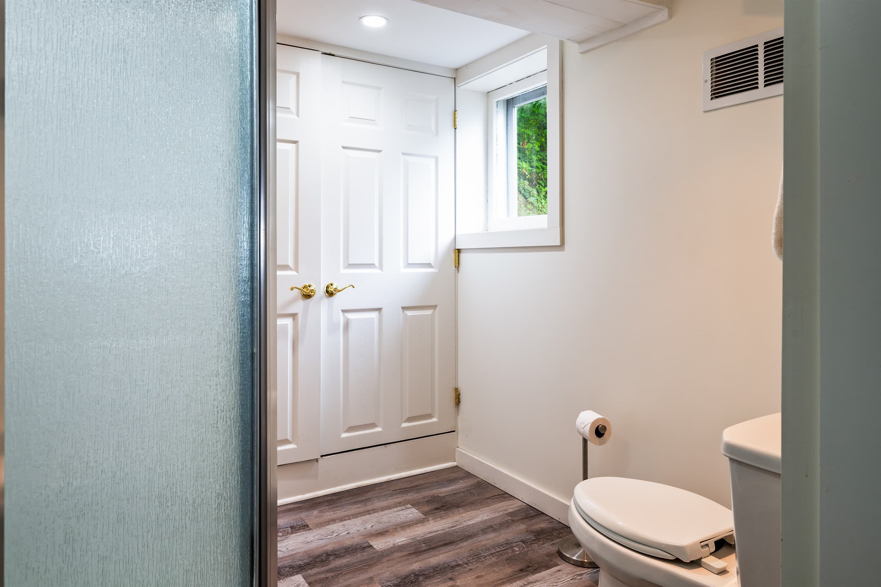 Bathroom with a frosted glass shower and dual-door closet space