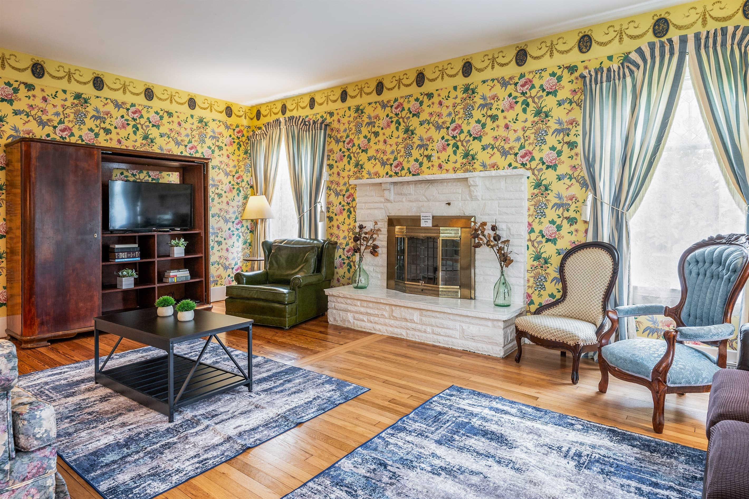 Sitting room with brick fireplace and armchairs