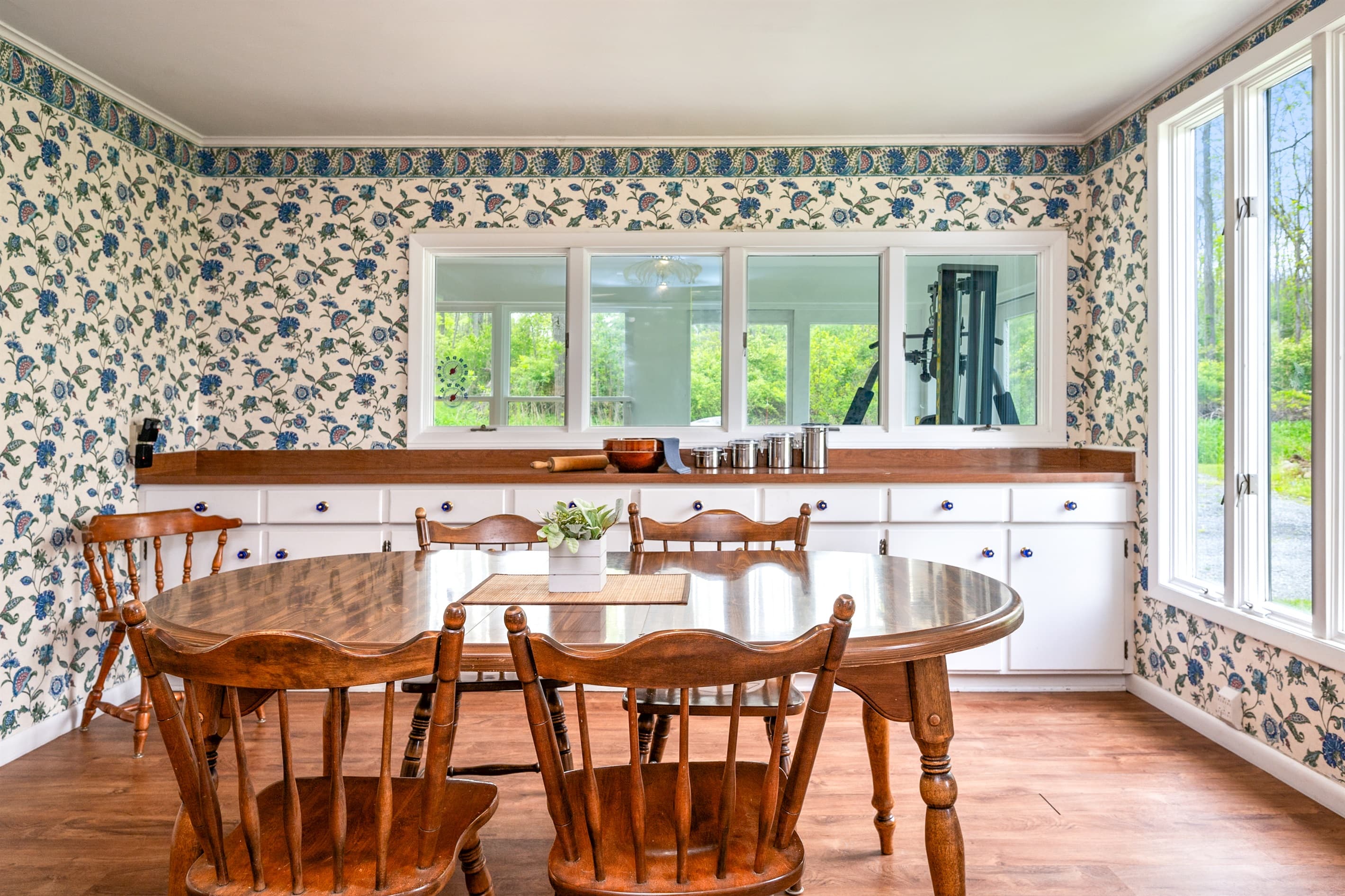 Dining room with patterned wallpaper and windows