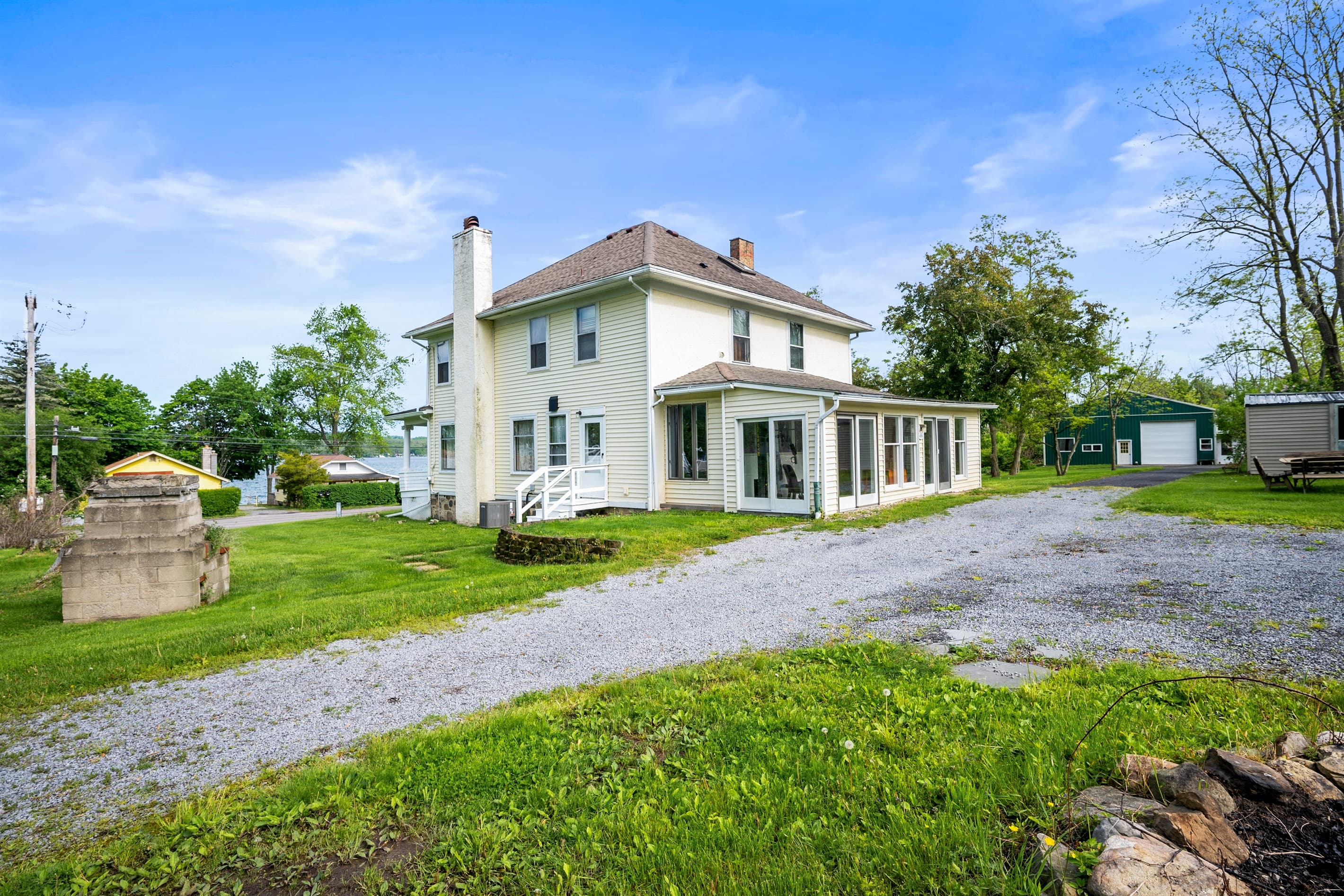 White farmhouse beyond wide front lawn