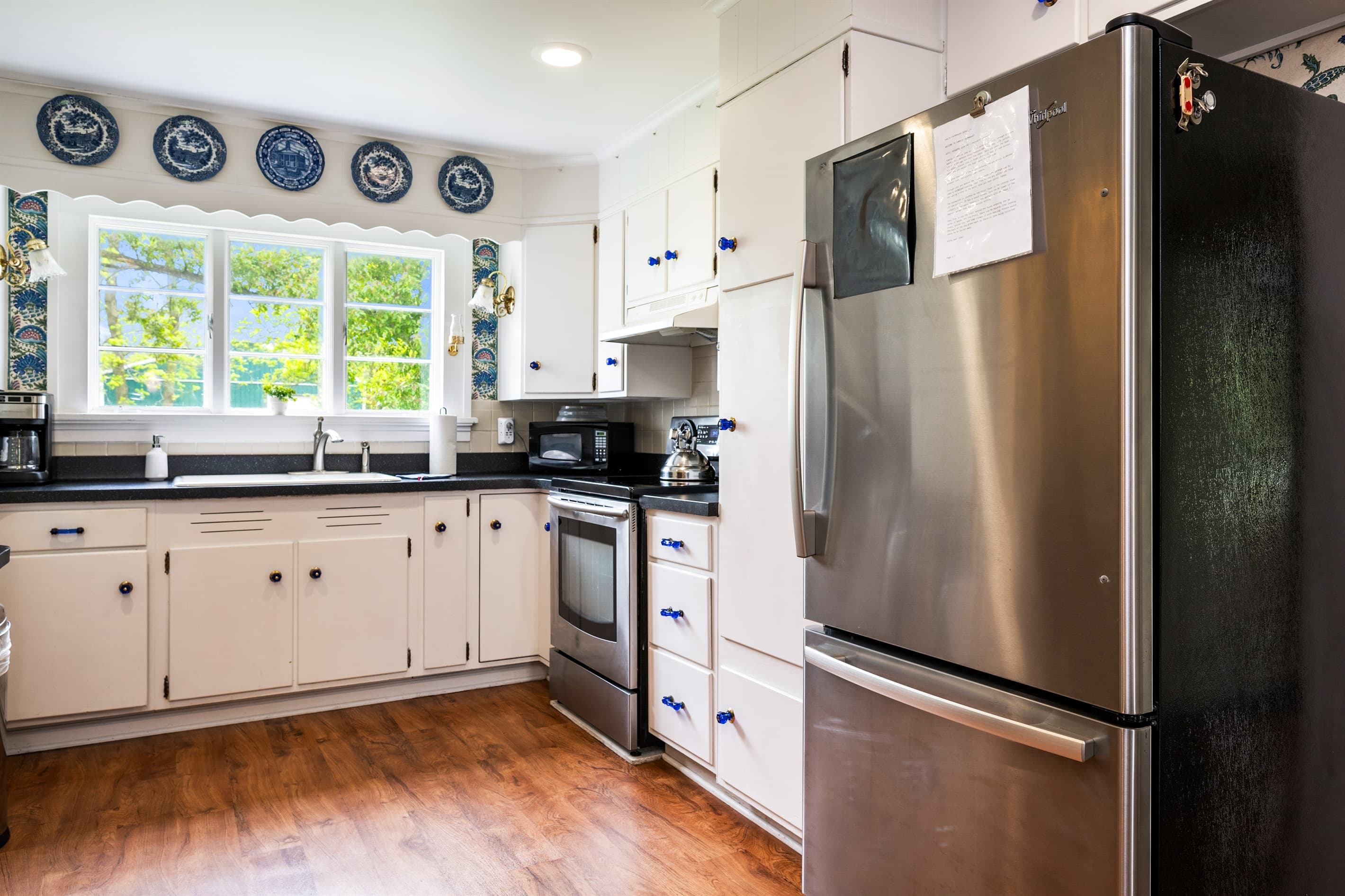 Kitchen with stainless refrigerator and light cabinetry