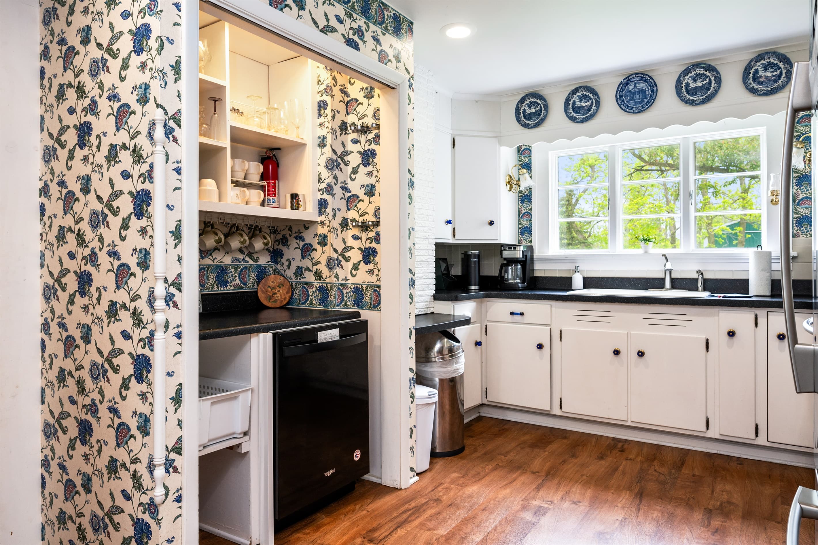 Kitchen beneath floral-patterned wallpaper