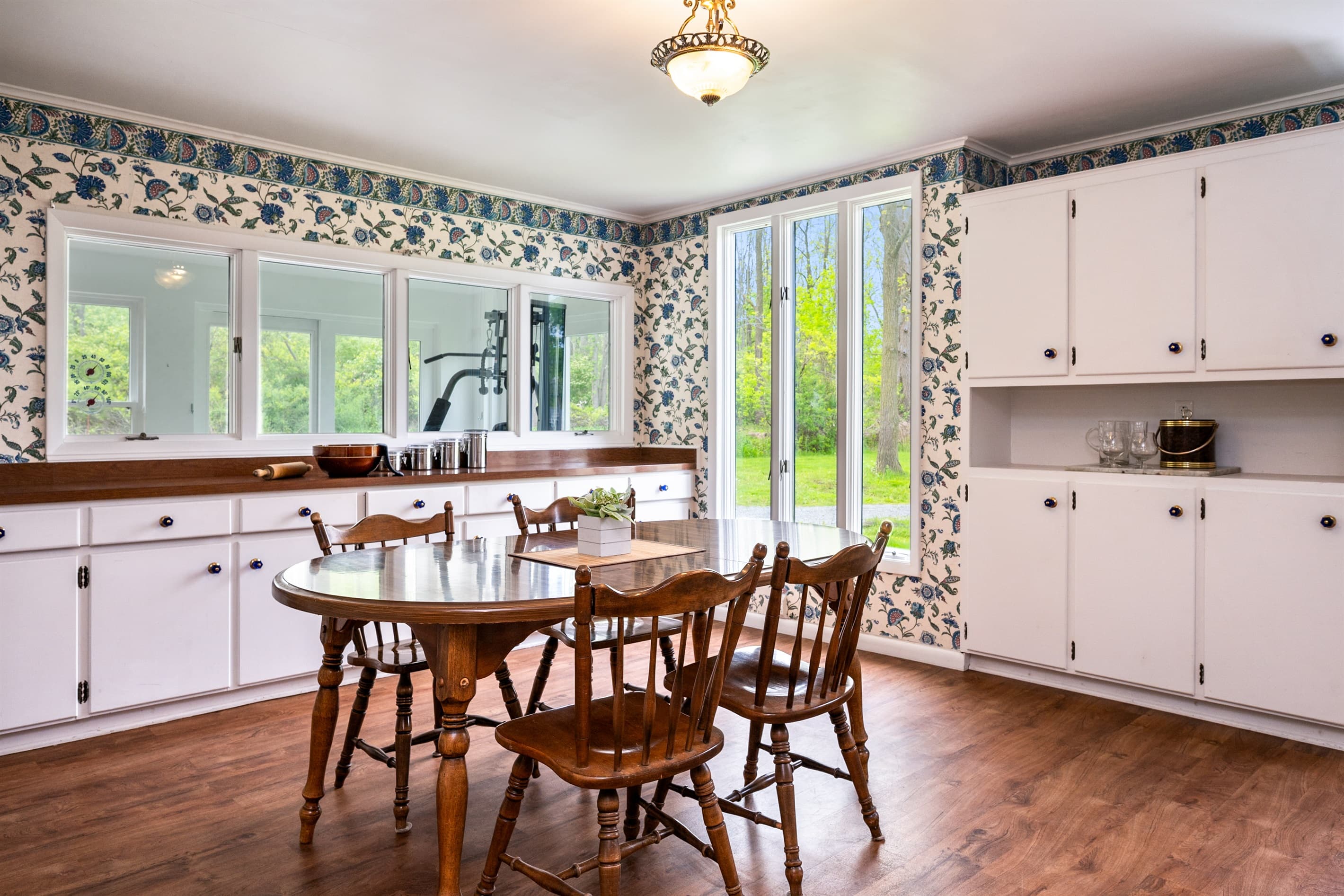 Dining table surrounded by garden-facing windows 