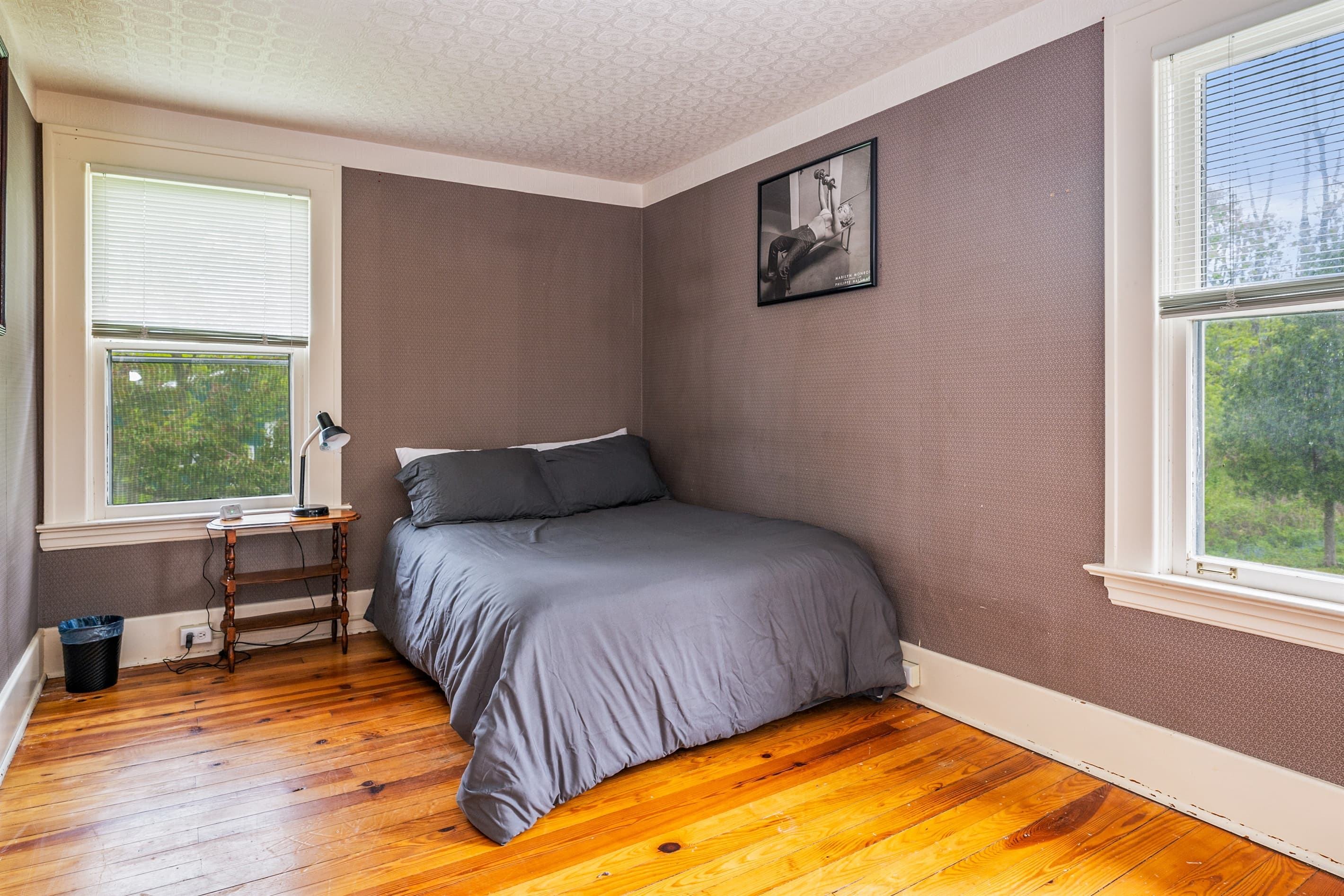 Bedroom with gray bedding and two windows