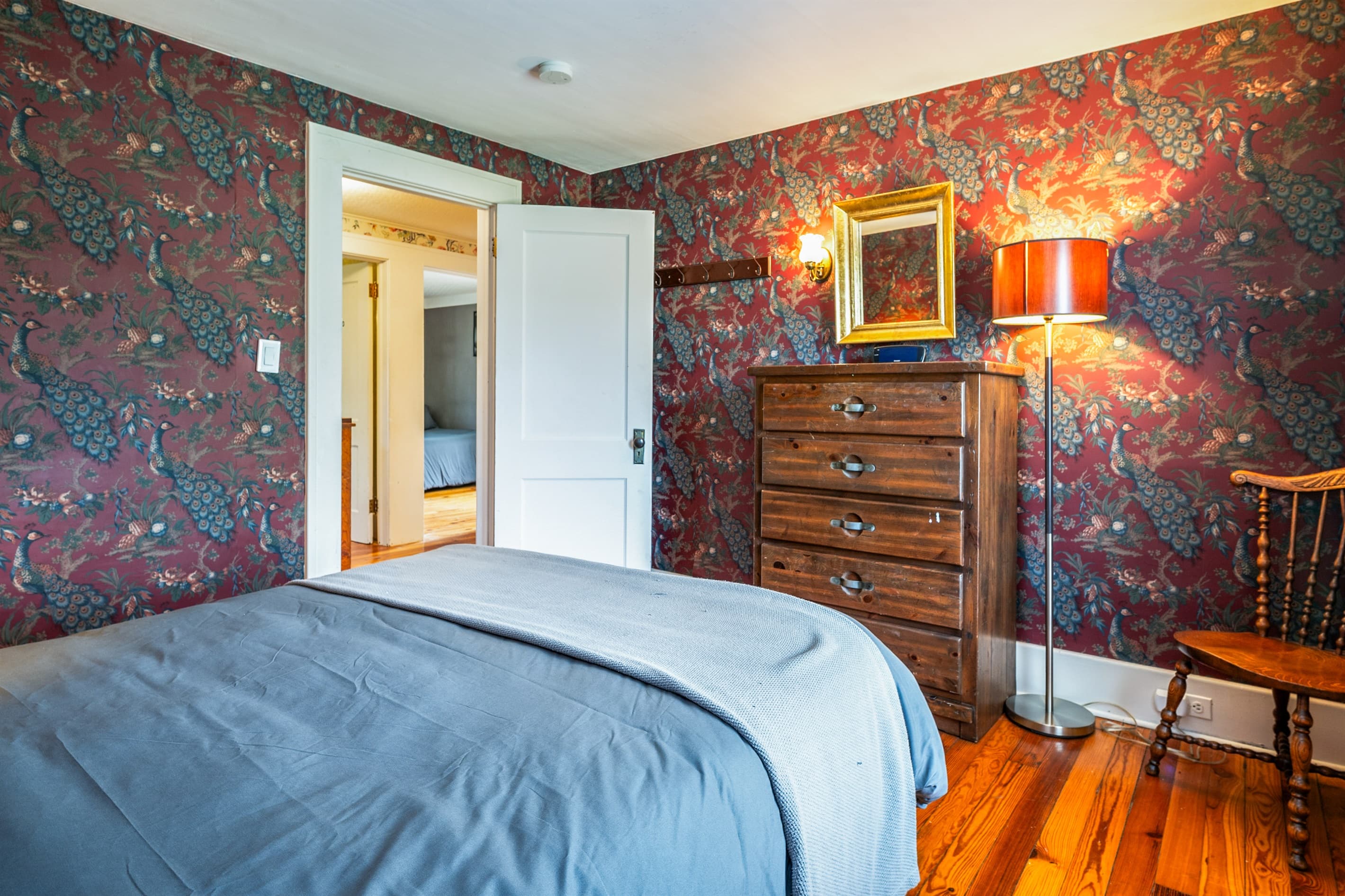 Bedroom with patterned wallpaper and wooden dresser
