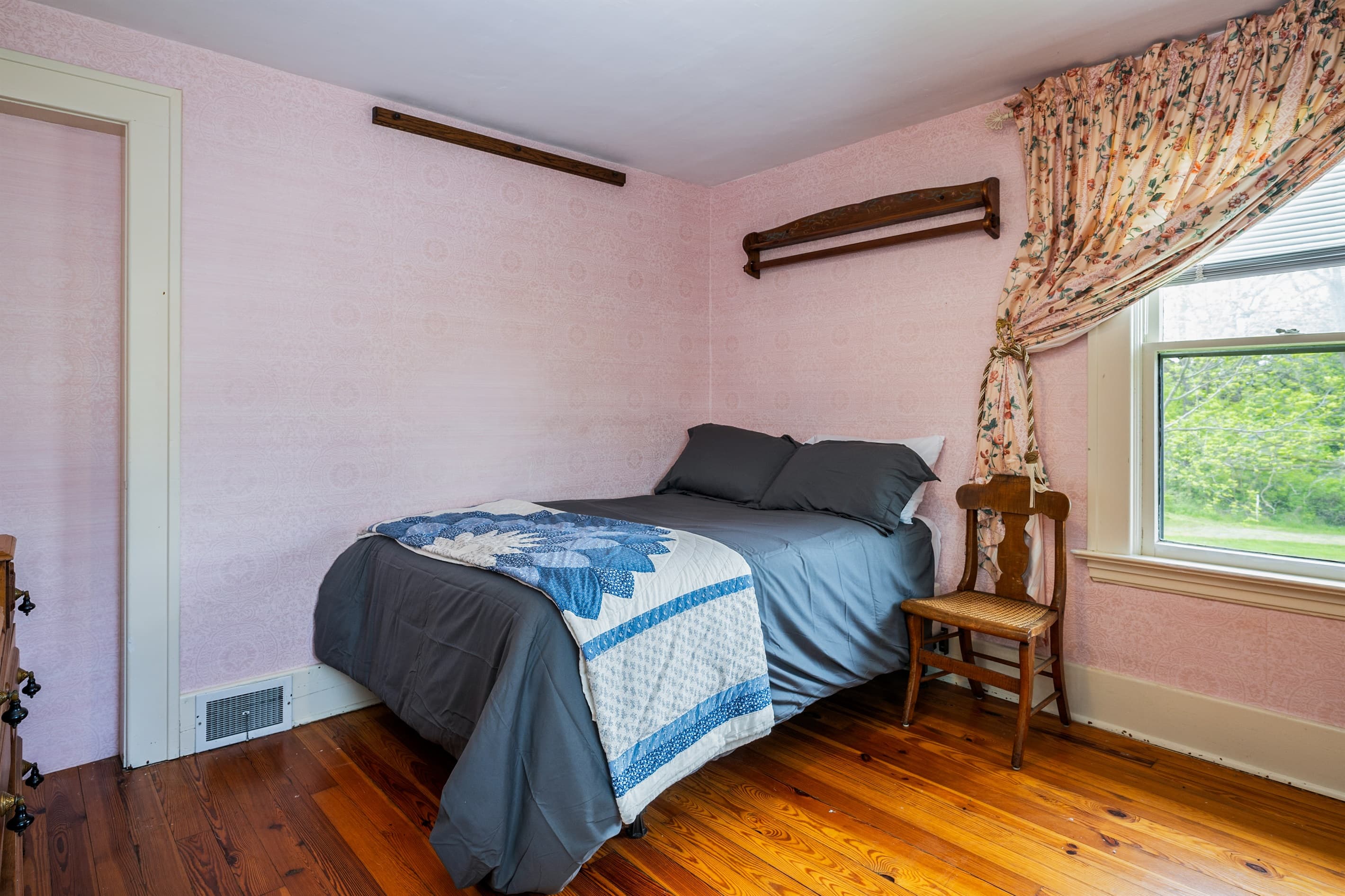Bedroom with blue bedding and pink wallpaper