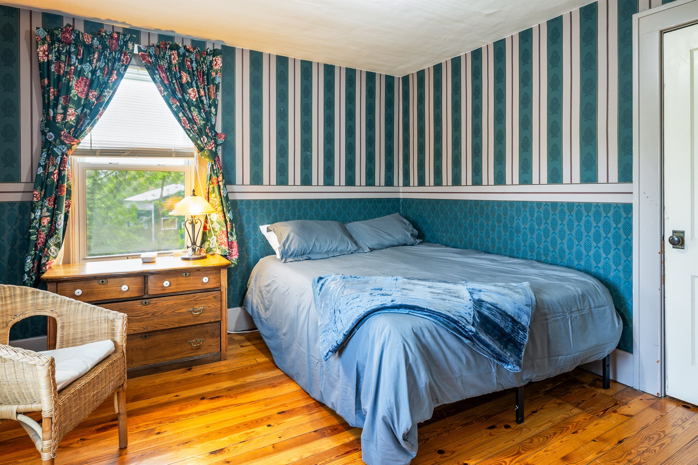 Bedroom with striped wallpaper and wooden flooring