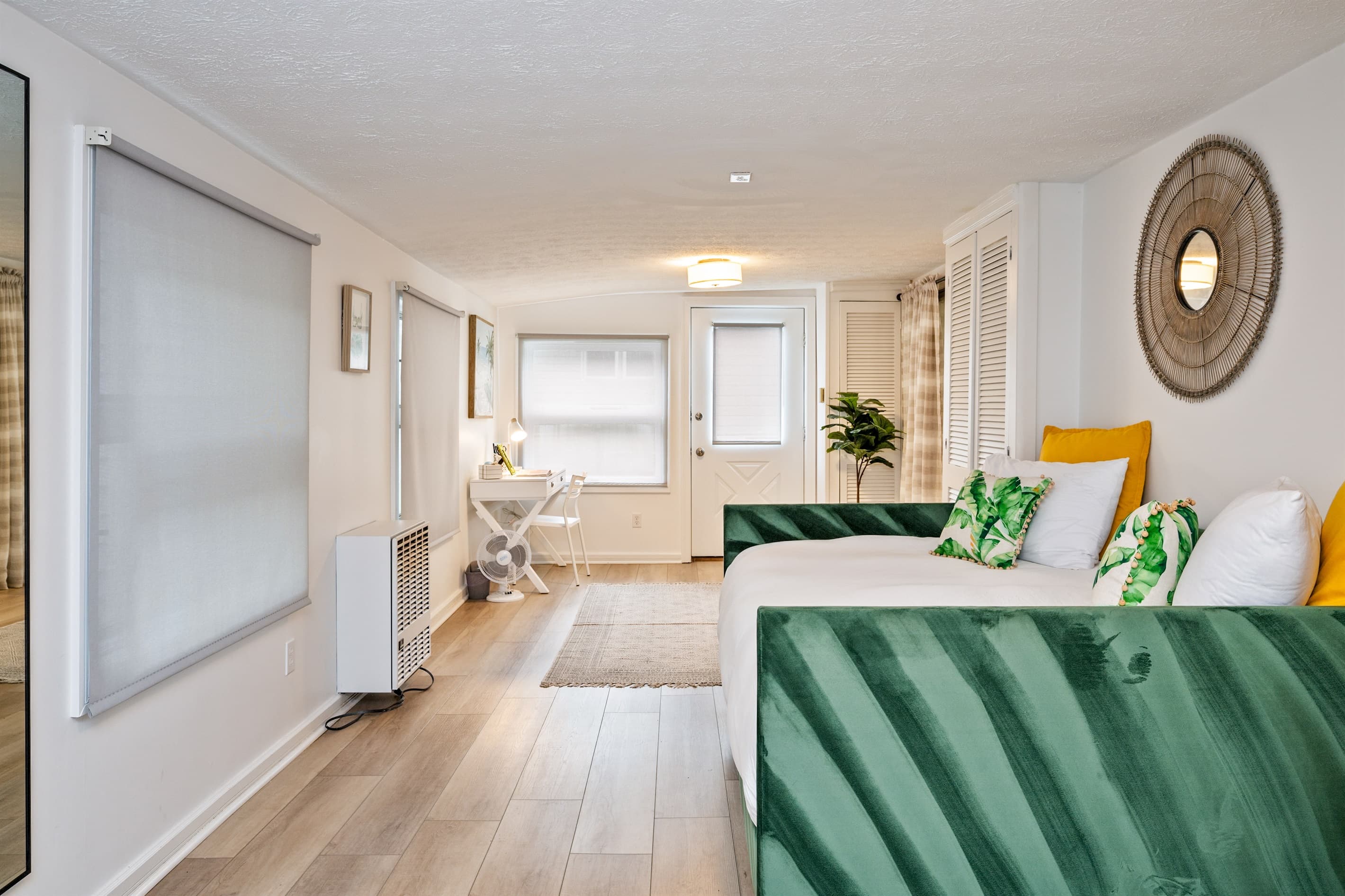 Studio sleeping area with green throw pillows