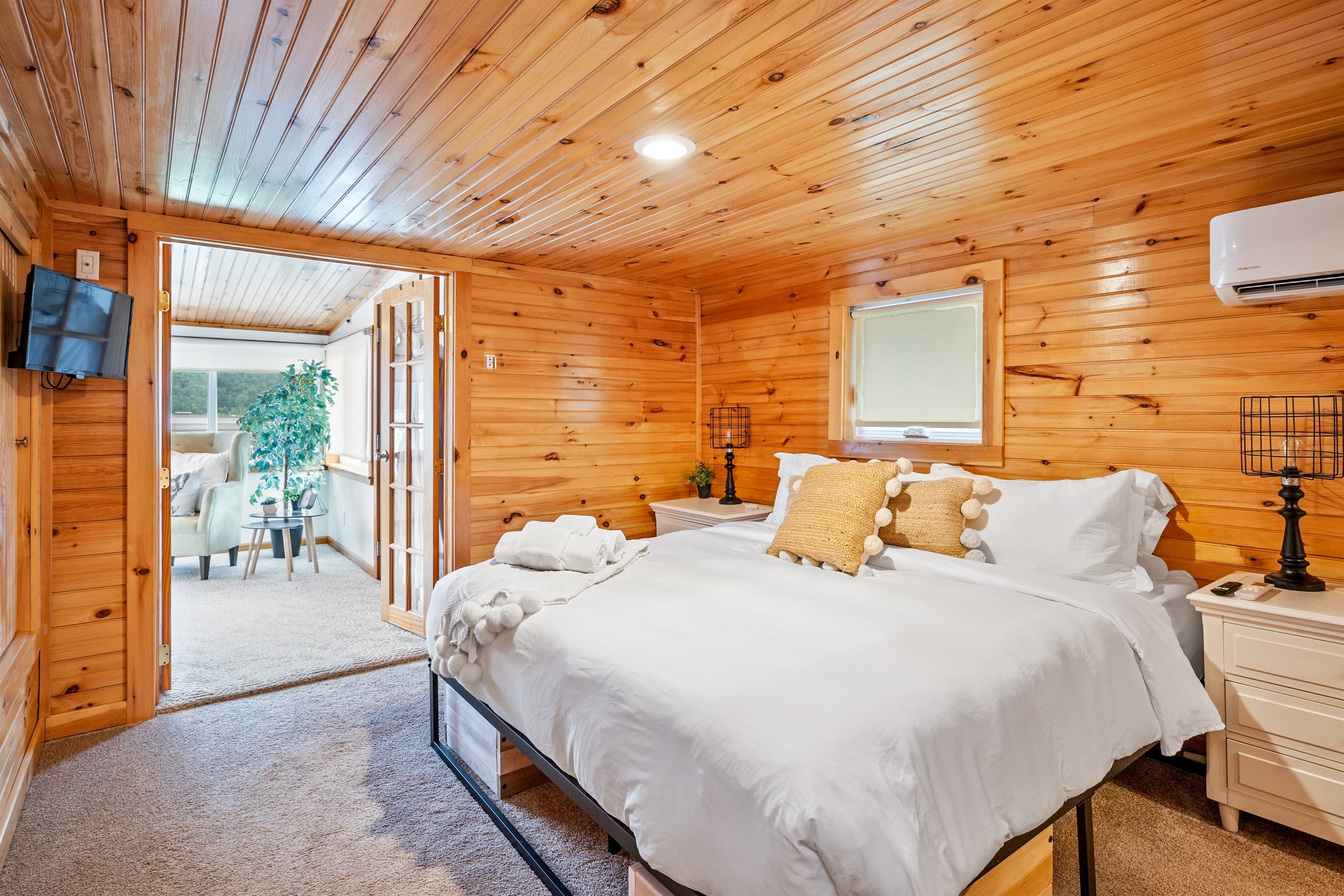 Bed beneath a wood-paneled ceiling