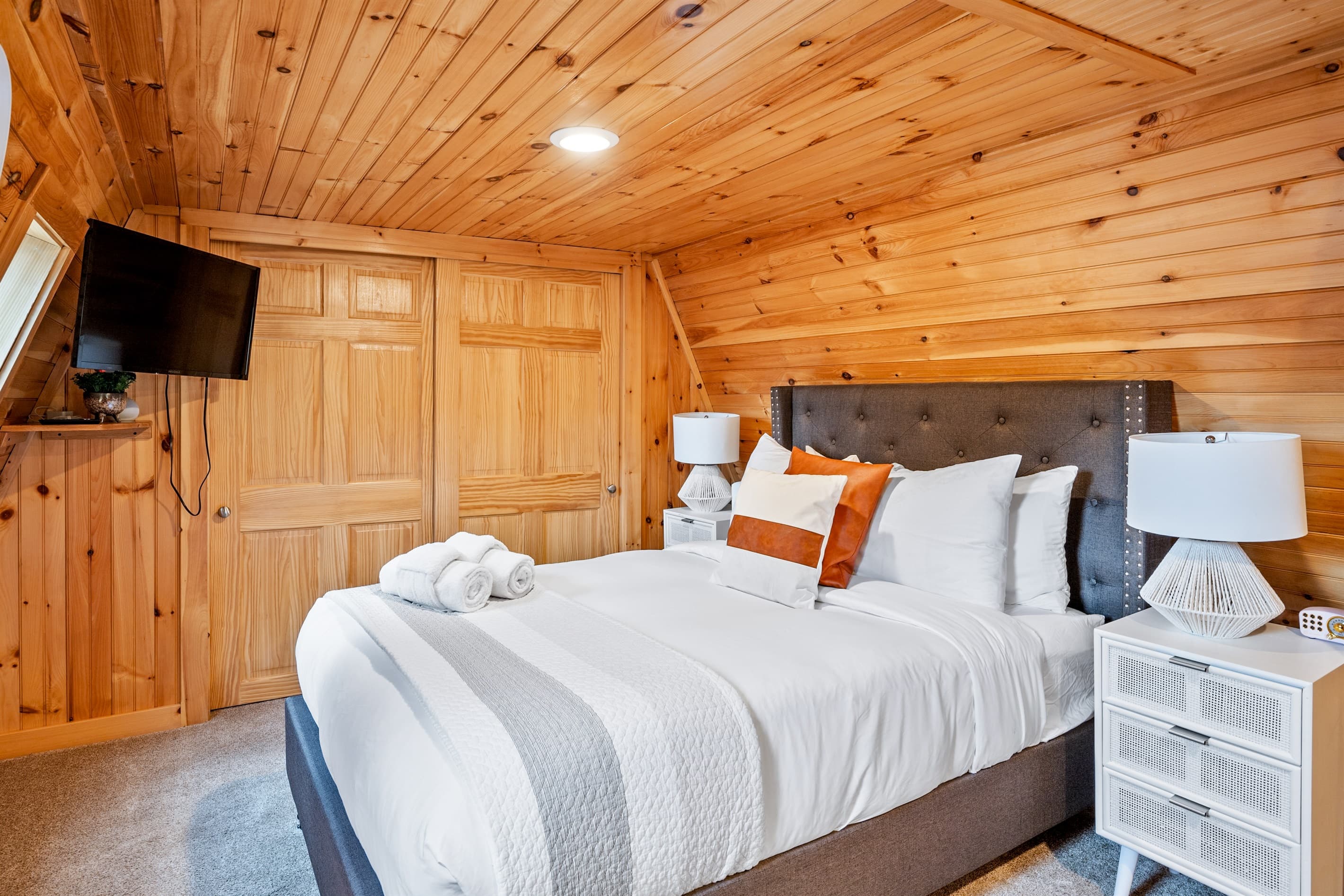 Wood-paneled bedroom with upholstered headboard