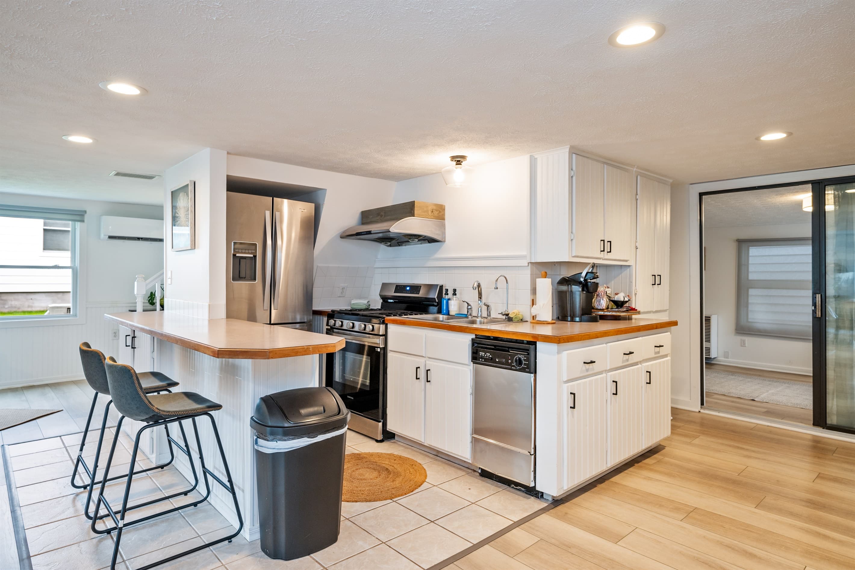 White kitchen with bar and black stools 