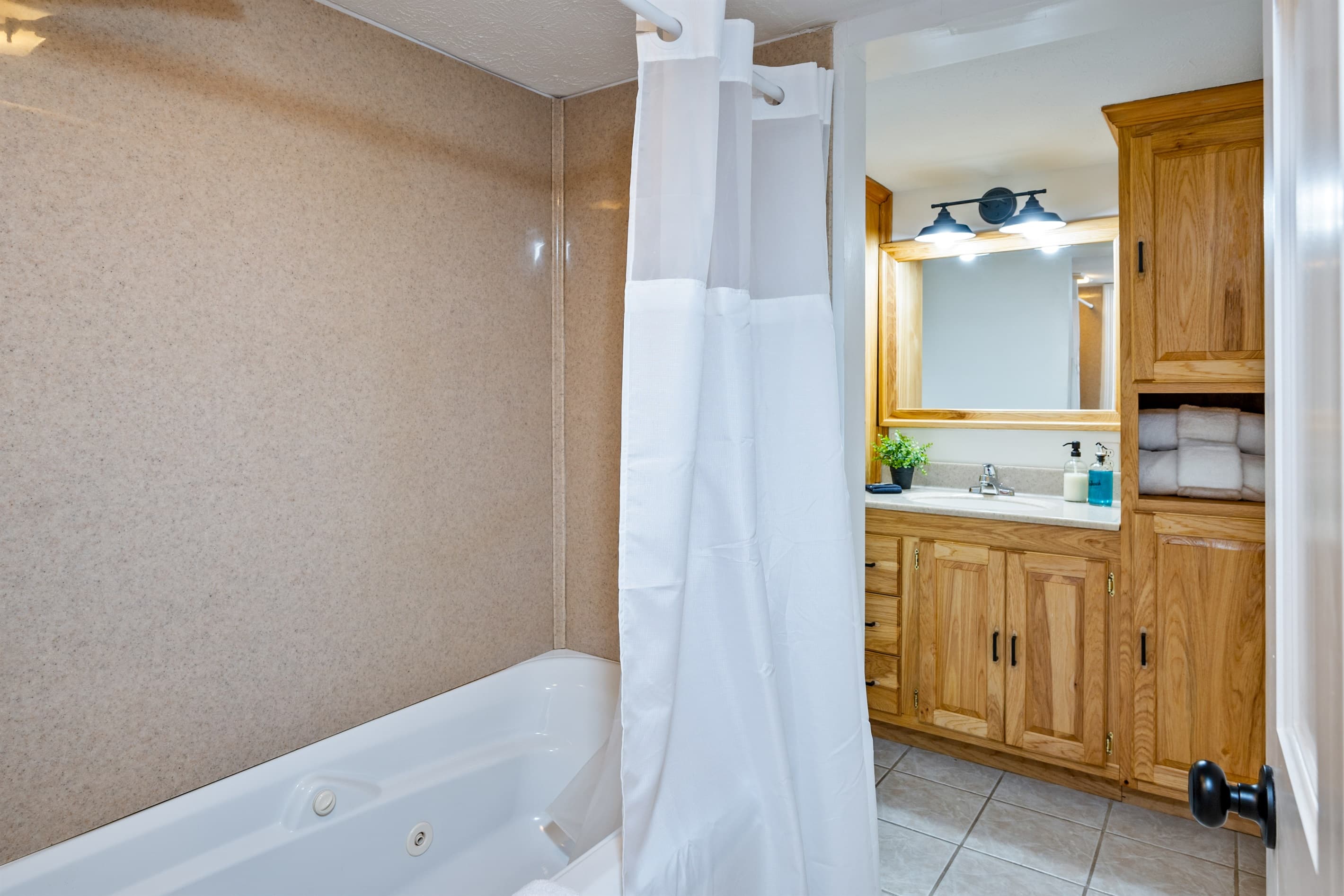 Bathroom vanity beside shower curtain