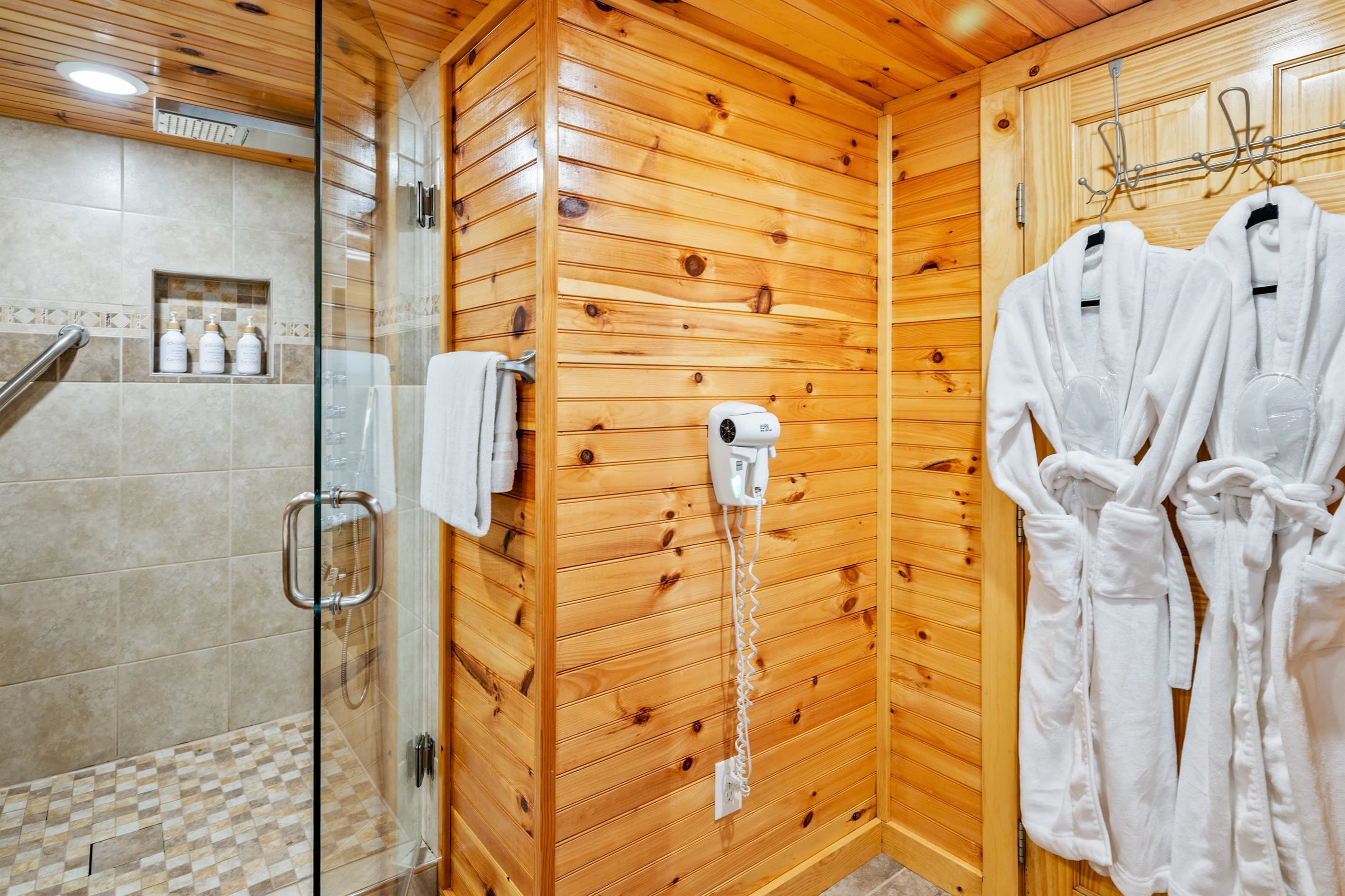 Glass-enclosed shower within wood-paneled bathroom