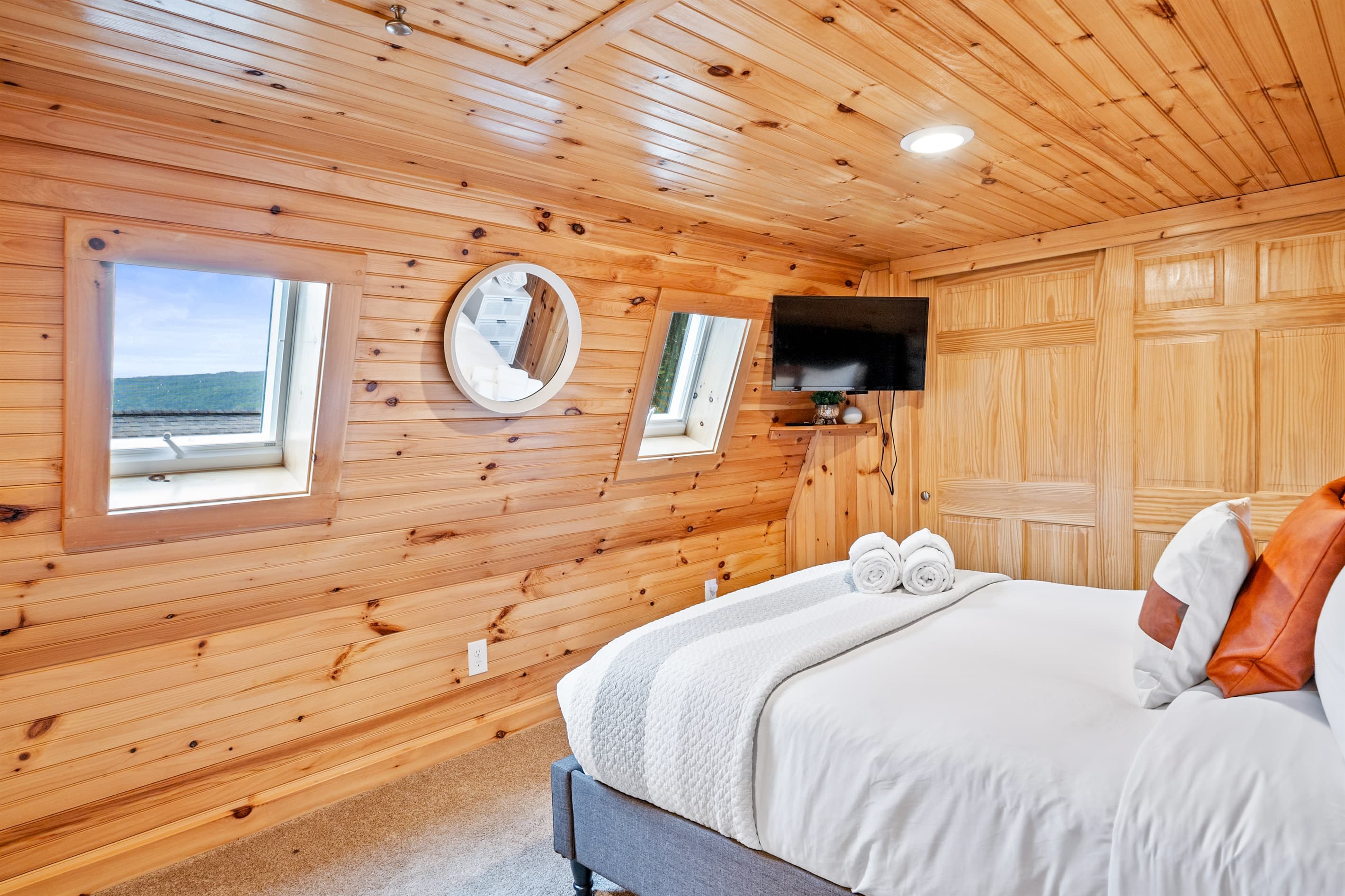 Wood-paneled bedroom with wall-mounted television
