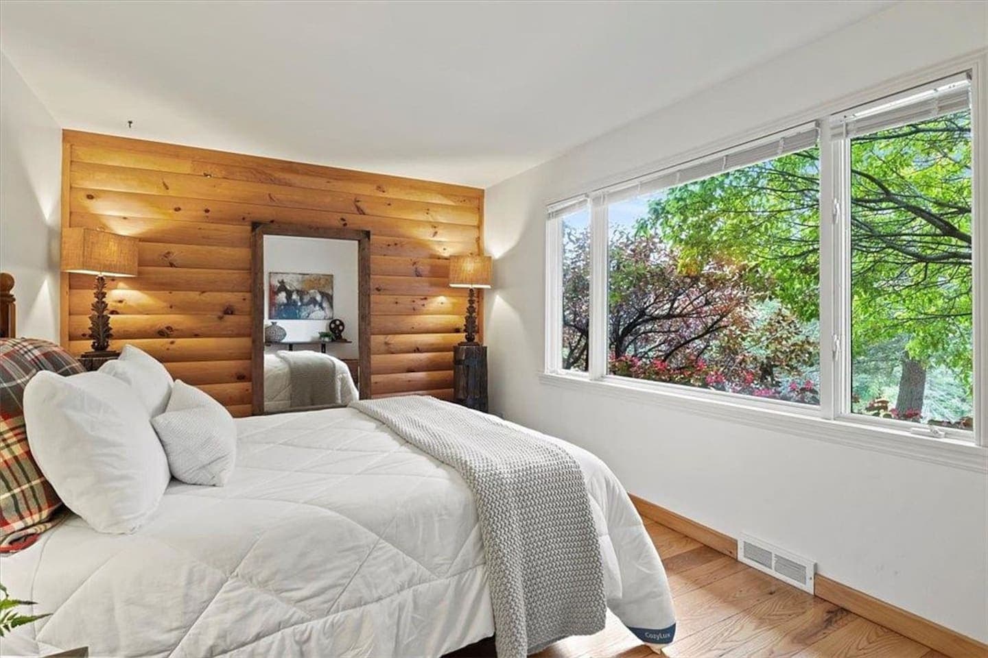 Bedroom with windows overlooking leafy surroundings
