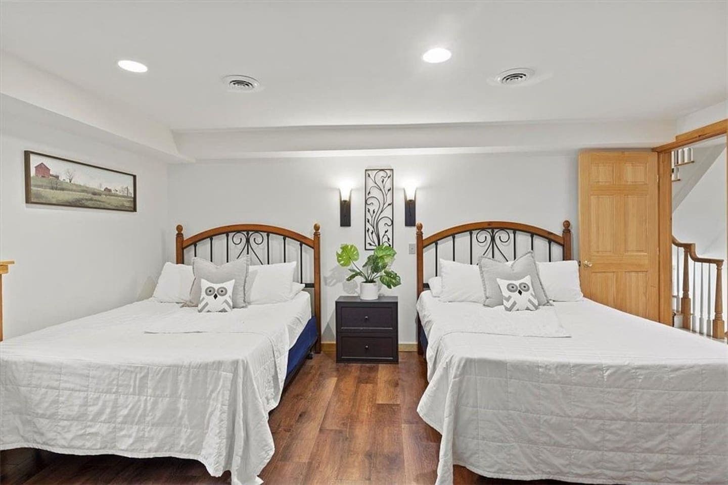 Bedroom with metal framed beds with a dark wood nightstand