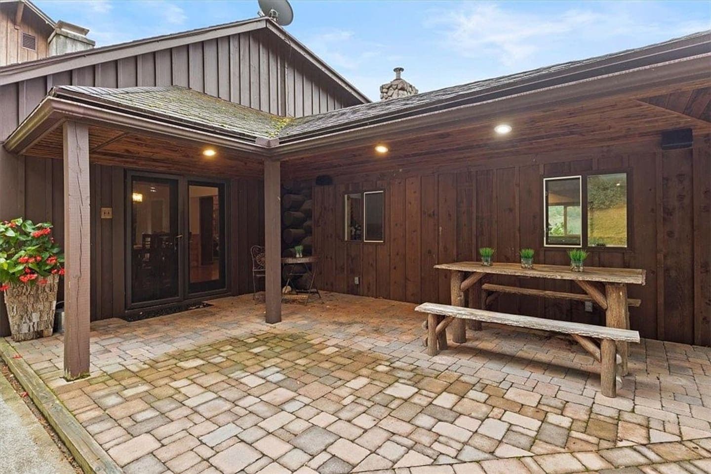 Covered patio with outdoor dining table and bench