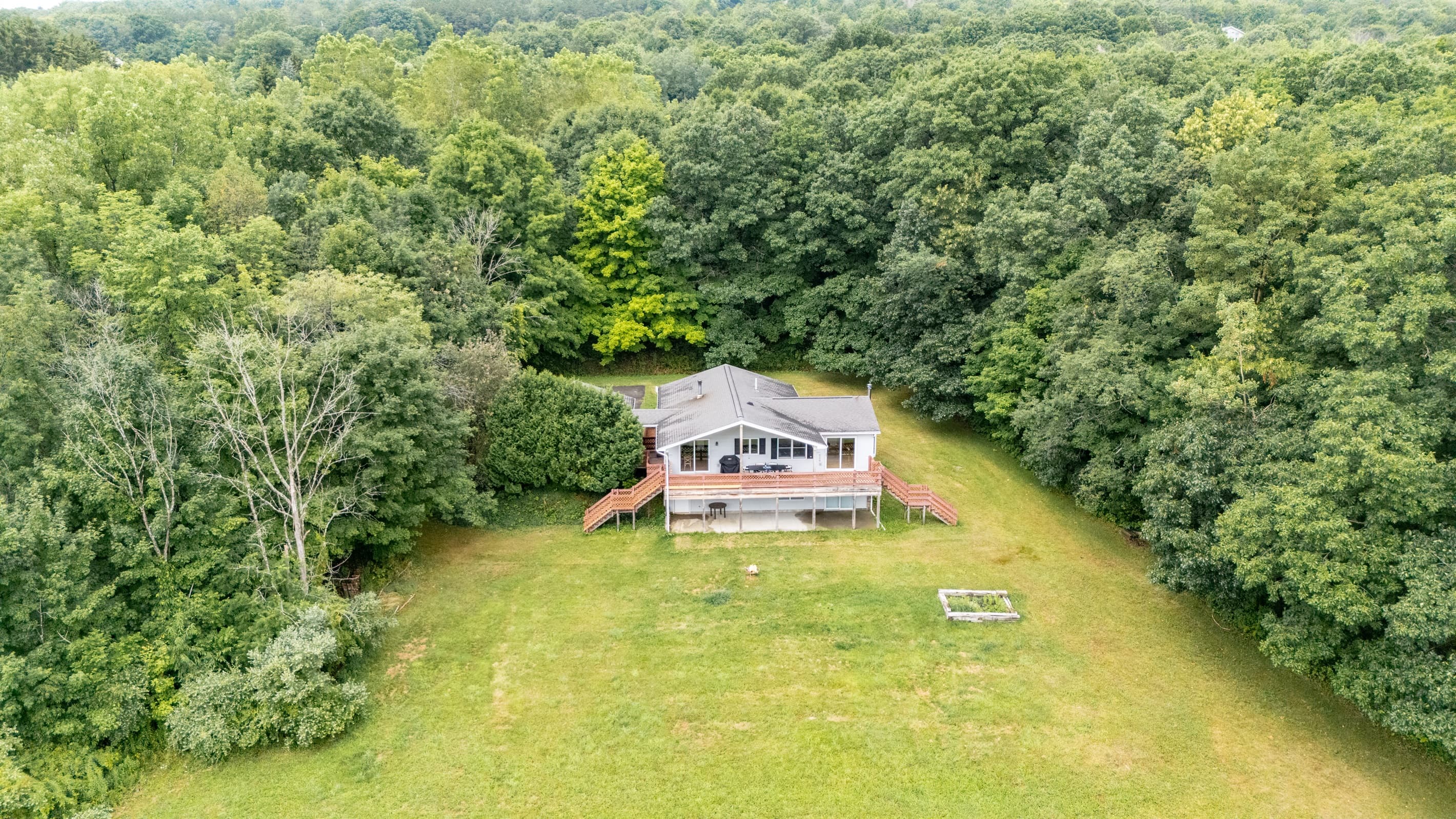House surrounded by open lawn and trees
